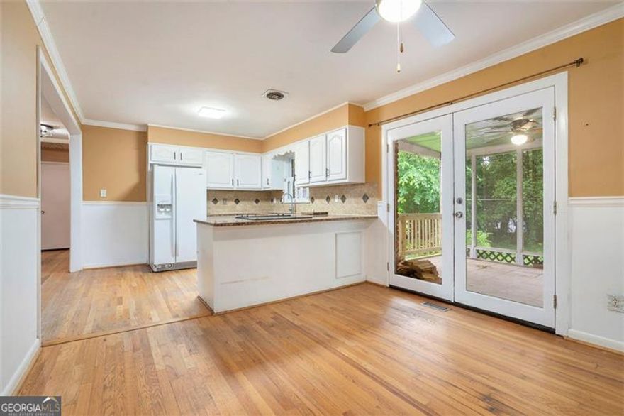 Beautifully updated four-sided brick ranch in pristine, move-in ready condition! This charming home features gleaming hardwood floors throughout and a renovated kitchen with white cabinetry, granite countertops, a stylish tile backsplash, and a convenient breakfast bar. The cozy family room includes built-in shelving and a warm fireplace-perfect for relaxing evenings. The primary suite offers a spa-like bathroom with a tiled floor, separate shower, and whirlpool tub. A spacious laundry room is conveniently located just off the kitchen. Enjoy the outdoors from the screened-in porch with tiled flooring, which opens to a large deck and a fully fenced, level backyard complete with a fantastic firepit-ideal for entertaining! Tucked away on a private, dead-end street, yet just minutes from I-75, shopping, dining, Truist Park, and The Battery-this home truly offers the best of both comfort and convenience.