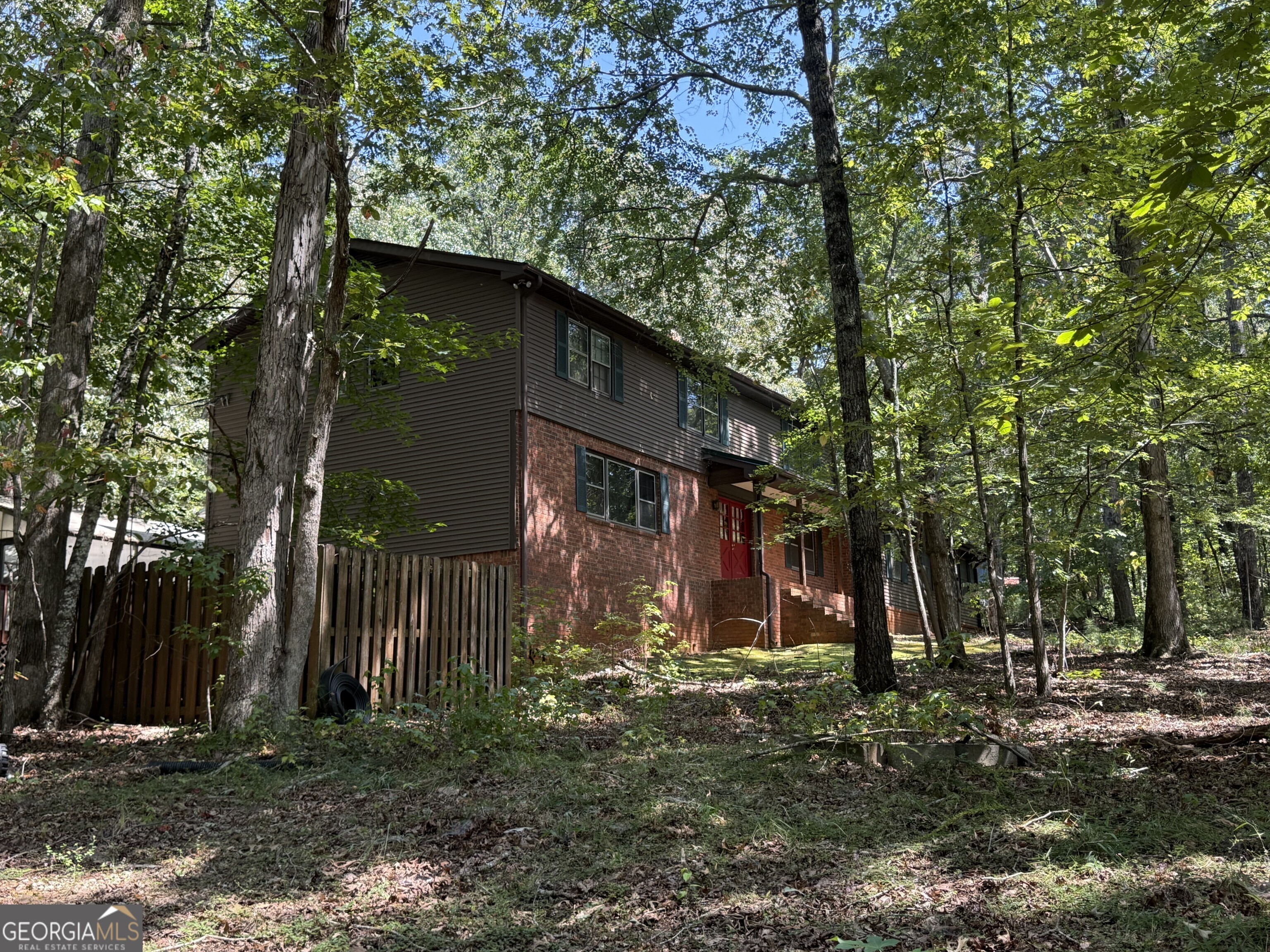 Discover the ENDLESS potential of this spacious three-sided brick home set on 6.5 private, gated acres. This one-owner property boasts a massive floor plan with room to truly make it your own. The main level features a large kitchen with breakfast area that flows into the sunroom, a formal living room and dining room, and a separate family room with fireplace. Upstairs, the oversized master suite is accompanied by 3 generously sized secondary bedrooms and a spacious hall bath. The basement offers abundant storage along with a finished office. In addition, a separate two-bedroom, two-bath apartment with its own entrance provides a full kitchen, living room, and laundry...ideal for in-laws, guests, or rental income! Unique amenities include an INDOOR POOL, metal roof, detached storage shed, and a covered pavilion perfect for additional parking or entertaining. Surrounded by mature trees for privacy, this solid home needs some TLC but could easily be transformed into a stunning SHOWCASE ESTATE!