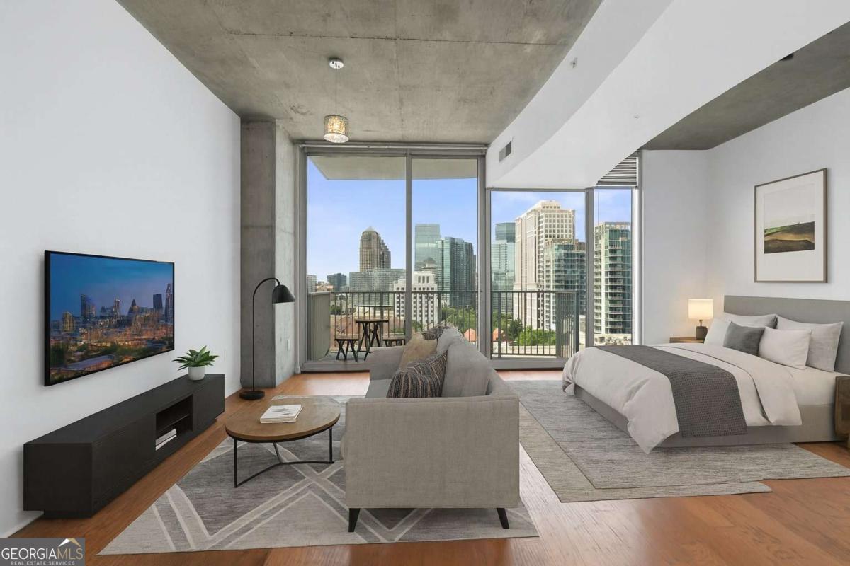 Discover modern city living in this spacious studio apartment at the highly sought-after Spire Midtown Condominiums. This rental offers breathtaking north-facing skyline views of Midtown. The well-appointed kitchen features granite countertops, tile backsplash, abundant cabinetry, and a moveable island, making it easy to cook and entertain. Despite being a studio, the smart layout provides ample space for a king-size bed, dining area, and full living room setup. A full-size washer and dryer are conveniently located near the bathroom. There is a large covered balcony off the living room. This studio has floor to ceiling windows, tall ceilings, hardwood floors, and a modern urban flare with cement ceilings. Residents of Spire enjoy luxury amenities including a 24-hour concierge, multiple fitness centers, a resort-style saltwater pool, outdoor grilling stations, and a stylish club room. This unit comes with the a deeded covered parking spaces in a secure garage. The location is unbeatable-steps from MARTA transit, dedicated bike lanes, and countless Midtown restaurants, shops, and cafes. Piedmont Park is just minutes away, and you can reach the airport or downtown without needing a car. Perfect for anyone seeking affordable luxury, unbeatable convenience, and a vibrant lifestyle in the heart of Atlanta.