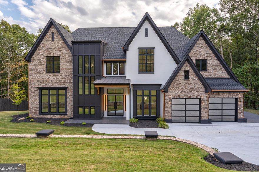 MOTIVATED SELLER! BRING OFFERS! From the moment you arrive at this gated estate, every detail of this custom built smart home speaks to refined luxury and modern innovation. Enter through double iron glass doors into a breathtaking two story foyer crowned with a crystal bulb chandelier. Seamless white oak hardwood floors throughout the home set the stage for timeless elegance. A formal dining room impresses with intricate ceiling detail, a designer chandelier, and a wall niche perfect for displaying your favorite art piece. The heart of the home is the expansive living room, complete with a detailed coffered ceiling, recessed speaker lighting, and floating shelves framing a Venetian plaster gas log fireplace. The gourmet kitchen is a showstopper, featuring quartz countertops, a breakfast-bar island with built in power, under counter storage & a microwave drawer, a JennAir WiFi-enabled double oven that has a gas range with a built in griddle, a wall mounted pot filler, hidden panel appliances, and a perfect spot for a coffee bar. A butler's pantry with a beverage chiller leads to a walk in pantry with extensive built in storage. Soft close cabinetry, under cabinet lighting, wine shelving, and a striking backsplash elevate the kitchen even further. The main level flows through a hallway connecting the three-car garage with epoxy flooring and attic access, the spacious laundry room with a sink, built in shelving, & a storage closet, a private office overlooking the serene back porch & spring-fed creek, and a beautifully appointed half bath with direct access to the outdoor living area. The primary suite is tucked away on this level as well and is a sanctuary with soaring cathedral-style ceilings, custom wall trim, statement lighting, and picturesque windows that flood the room with natural light. Talk about a spa inspired bathroom! This ensuite bath dazzles with double vanities, a dedicated makeup vanity with touch-light mirror, a free standing soaking tub against a marble herringbone accent wall, a water closet with a motion activated toilet & a bidet with adjustable water temperature, and an oversized glass shower with rainfall & dual shower heads, built in seating, and a wall niche for storage. It doesn't stop there! The master closet is a dream come true, featuring motion sensor lighting, custom shoe shelving, jewelry drawers, pull-out organizers, extensive cabinetry, and a built in oversized mirror. An additional downstairs bedroom includes a walk-in closet with shelving and under stair storage. Right next to this room is a full bathroom with a double vanity and a glass walk-in shower. Along the stairs, a landing with floor to ceiling windows leads the way to two spacious bedrooms, each with custom walk-in closets. A full bath with tile flooring, and cabinet shelving for optimal linen and toiletry storage is shared between the rooms. A versatile loft area with built in speaker lighting provides the perfect second living space, while a private movie theater room with double doors, projector & surround sound wiring, floor lighting, and a dedicated electronic closet creates a true cinematic experience. The outdoor living is equally impressive, with a slate floor covered patio featuring wood-lined tongue & groove ceilings, a brick fireplace with cedar hearth, and a built-in grilling station complete with a sink, refrigerator, and storage. Imagine watching your favorite sports team out here! Every detail of this home has been carefully curated, from custom chandeliers, crown molding, wall and floor trim, to black and gold fixtures throughout. Modern conveniences abound with dimmable lighting, speaker-integrated fixtures, WiFi thermostats, and an advanced smart home system controlling appliances, lighting, HVAC, irrigation system, security, and more! The door locks are fingerprint, facial recognition, and coded entry. This property is the pinnacle of luxury, advanced technology, and livability. Make this your private retreat NOW!