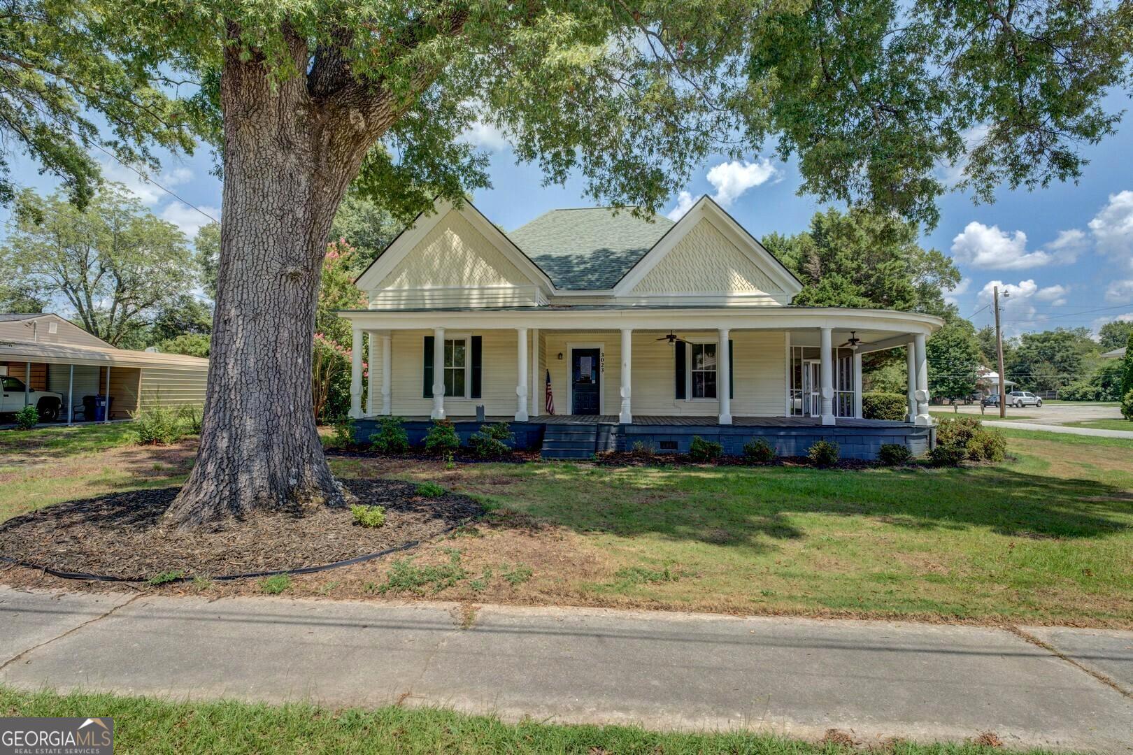HISTORICAL SOUTHERN CHARM IN THE SMALL SOUTHERN TOWN OF MANSFIELD. This updated, yet full of original southern charm home in downtown Mansfield just may be THE ONE for you! Wait until you grace the front porch and open up the beautiful stained glass front door to see this amazing foyer with 13ft ceilings, original pine hardwood floors that have just been refinished and fresh interior paint. The HUGE family room will surely be a great place for gathering and making memories with family. The large primary bedroom has a renovated bathroom with double vanities, a large closet AND also gives access to the screened in porch! The 2 additional bedrooms are surely to provide plenty of room for children, family or guests. This home offers a large kitchen with stainless steel appliances, gas stove, solid surface countertops, plenty of cabinets, a large island as well as a nice, roomy pantry. Finding a place for everything in this kitchen should not be a problem. A spacious 20x20 detached garage provides parking, storage, room for those hobbies or whatever your need. The separate outbuilding will provide plenty of storage for lawnmower, yard tools, etc. The fenced in backyard is the perfect play area for your children and/or pets. The newer roof was installed in 2020! This home has all the historic charm with many updates! Conveniently located walking distance to Mansfield Elementary School, the Post Office and downtown as well as just a short drive to the Mansfield Marketplace as well as Beaver Park. Located on Hwy 11, convenient to I20, Covington, Newborn, Social Circle, Monticello Madison and so much more!