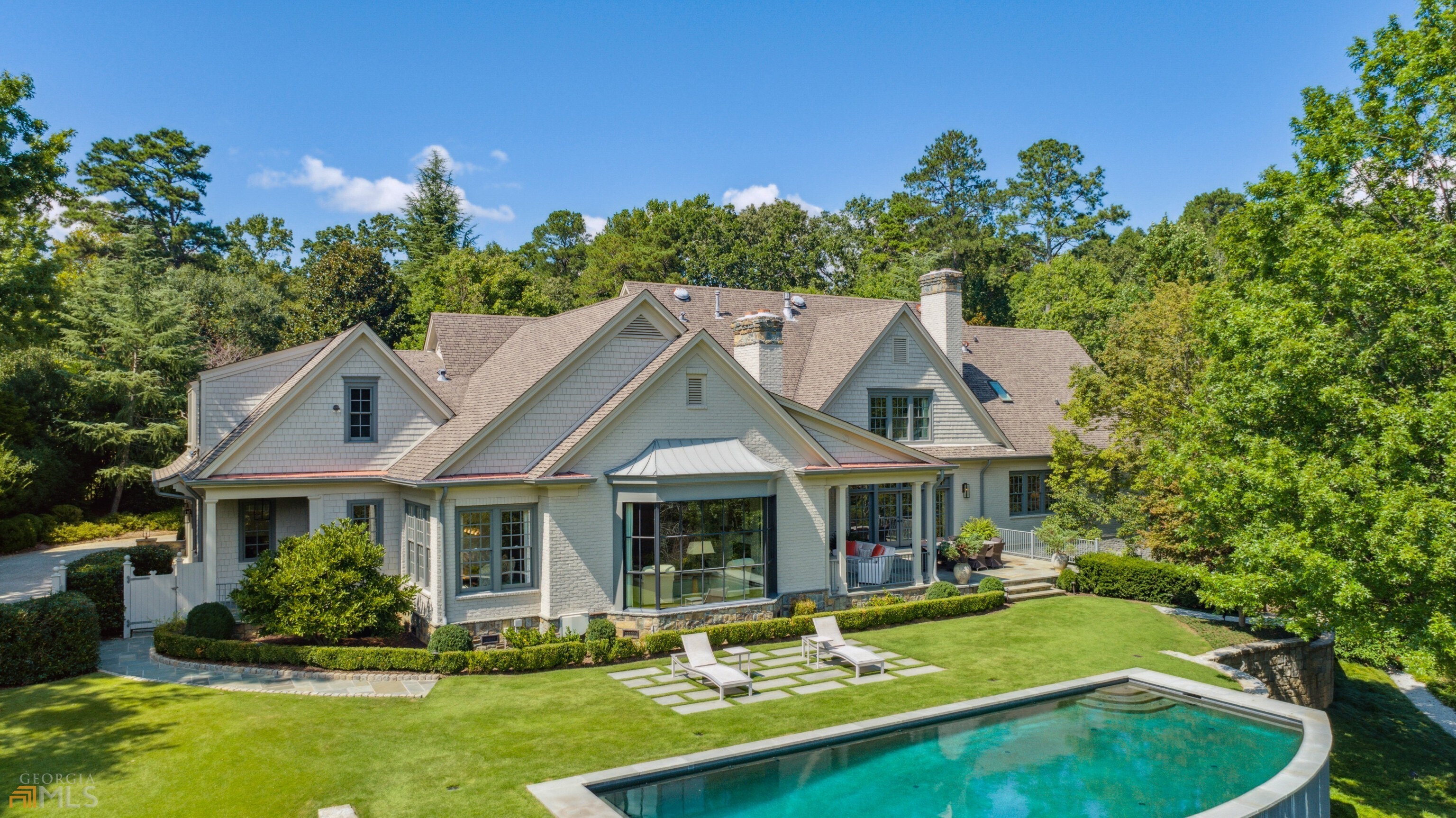 Beautifully updated and meticulously maintained custom built home on private 2.2+ Acre lot. This understated elegant home is perfect for large-scale entertaining, yet very comfortable and ideal for everyday living. It is located close to excellent schools, both private and public and sits just outside the Atlanta city limits in the most prestigious estate area of Sandy Springs. A large steel bay window wall in beamed great room overlooks heated/salt water pool and grassed area large enough for all kinds of sporting activities. Walk out of the living room French doors to bluestone patio and covered porch with masonry fireplace and built-in grill. Primary bedroom on the main level with stunning bath...Atlanta Homes & Lifestyles 2019 Bath of the Year-Custom Design Galleria vanities/linen cabinet, heated floors, remote controlled blinds, Neolith countertops and shower wall. Private access from Primary bedroom to adjacent library with bookcases and lacquered paneled walls. Formal dining room with timeless moldings and hand painted wallpaper. Wine cellar created with the wood from the old original barn. Unfinished daylight basement ready to finish, if needed (already stubbed for bath and has a masonry fireplace). Loads of features: 3-car garage ready for electric cars, plenty of storage/closets, basketball goal, fully fenced in walk out backyard, 2 wells for front and rear irrigation, sound proofing between floors, high ceilings, rich hardwood floors, 8 ft door and cased openings, dual stairways, mature trees and lush landscape with extensive landscape/moon lighting, cobblestone lined washed aggregate drive, and guest parking area. Convenient to interstates, shopping, restaurants and Chastain Park!