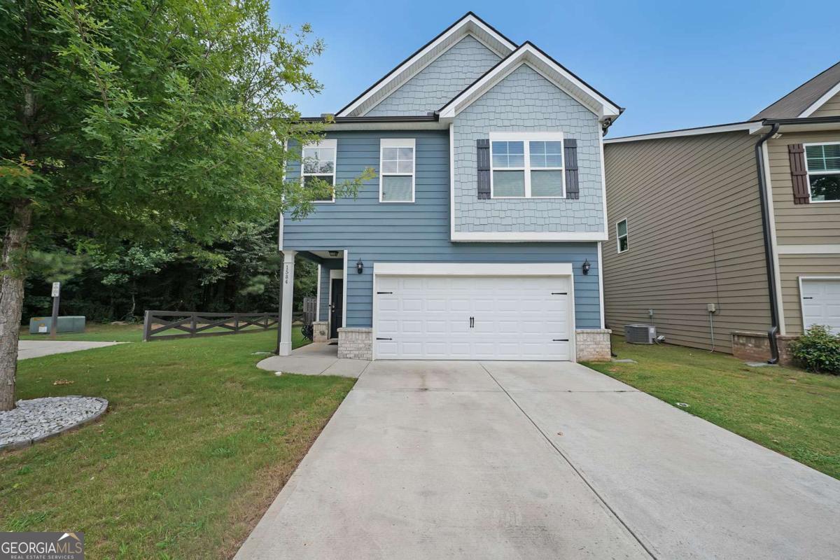 This beautifully maintained home sits on a desirable corner lot and features a two-car garage equipped with an EV charging station. Ideally located near golf courses, Georgia State campus, and Stone Mountain Park for endless outdoor recreation. Enjoy easy access to shopping, dining, and I-285 for a smooth commute. Inside, the open-concept floor plan welcomes you with hardwood floors and a warm, inviting atmosphere. The family room is anchored by a classic fireplace, flanked by floating shelves and built-in storage. The adjoining kitchen and dining area boast granite countertops, a large island with breakfast bar, subway tile backsplash, stainless steel appliances, and ample counter space, perfect for prep, serving, and entertaining. Step outside through the dining area to a covered back patio, offering a seamless flow for indoor-outdoor living. A convenient half bath completes the main level. Upstairs, a versatile flex space provides the ideal spot for a reading nook, home office, playroom, or lounge. The oversized primary suite features a double vanity, soaking tub, and a walk-in shower. Three additional bedrooms are generously sized, and two full bathrooms offer plenty of space for family or guests. Outside, the home features both an invisible fence and privacy fencing for peace of mind. The wooded views and a protected creek behind the property create a serene, natural backdrop. Whether you're enjoying quiet evenings on the covered patio or entertaining guests, this home checks all the boxes for comfort, style, and location.