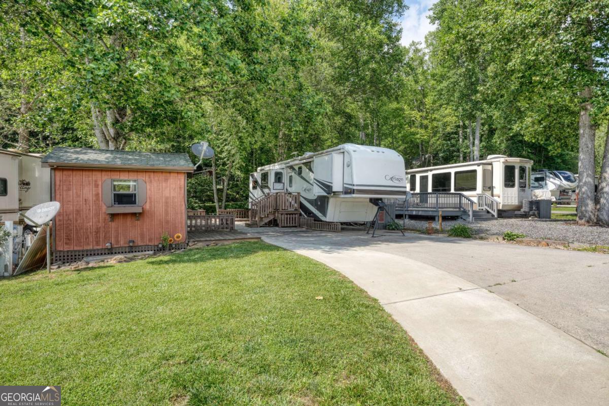 Discover peaceful creekside living with this very well-maintained 1BR/1BA RV located in a charming, quiet park. Nestled on a beautiful creek front lot, this property features a spacious deck overlooking the serene water-perfect for morning coffee or evening relaxation. A separate storage shed offers flexibility as a workshop, man cave, or additional storage space. The park is well-kept with paved roads, and your HOA dues cover sewer, water, garbage, and lawn care, making maintenance a breeze. Conveniently located close to Vogel State Park, Helton Falls, and Brasstown Bald, this is your ideal mountain retreat or weekend getaway.
