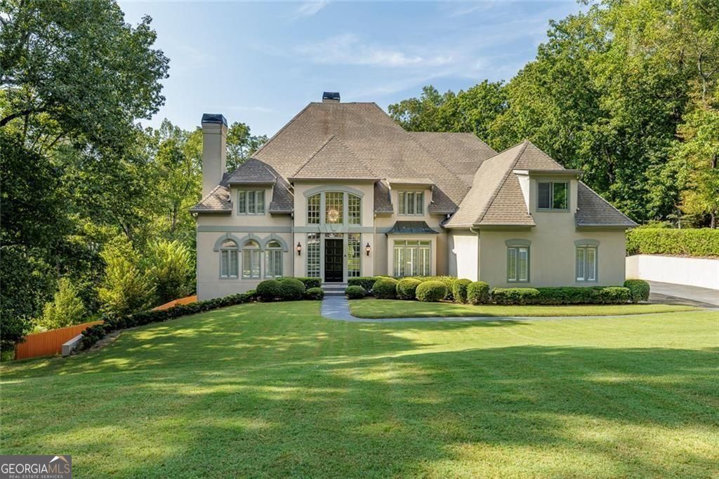 This stunning home, beautifully designed and thoughtfully renovated, sits on over an acre in a private cul-de-sac in the desirable Jett Ferry Manor neighborhood. Surrounded by professionally landscaped grounds, the home has been impeccably maintained and offers the perfect blend of elegance, comfort, and modern sophistication. The grand two-story marble foyer opens to soaring ceilings, hardwood floors, and both front and rear staircases. The formal living room with fireplace flows into a banquet-sized dining room, while the breathtaking two-story great room features a dramatic wall of windows, stacked-stone fireplace, and custom cabinetry, opening to an expansive two-tier deck overlooking the private fenced backyard. The chef's kitchen is a showpiece with custom white cabinetry, quartz counters, tile backsplash, professional-grade appliances, walk-in pantry, and a large center island where family and friends are sure to gather. A bright breakfast room with skylights connects to the vaulted family room with fireplace, creating an inviting everyday space. The oversized owner's suite has an optional sitting area, spa-inspired bath, dual vanities, soaking tub, walk-in shower, and two spacious walk-in closets. Upstairs are three large ensuite bedrooms with large walk-in closets. A hidden sitting room is shared by two of the bedrooms-perfect for teenagers. The terrace level is built for entertaining and is equipped with a game room, full bar area, family room with fireplace, home theatre with custom seating and a state-of-the-art sound system. Not to be missed is a spectacular night sky ceiling. Additional spaces include a bedroom, full bath, office, exercise room, and flexible areas for whatever your lifestyle requires. With four fireplaces, new windows, an open layout, and attention to detail throughout, this home truly has it all. Located in Sandy Springs, it's close to top public and private schools, shopping, dining, Dunwoody Country Club, and has offers convenient access to interstates for enjoying all Atlanta has to offer.