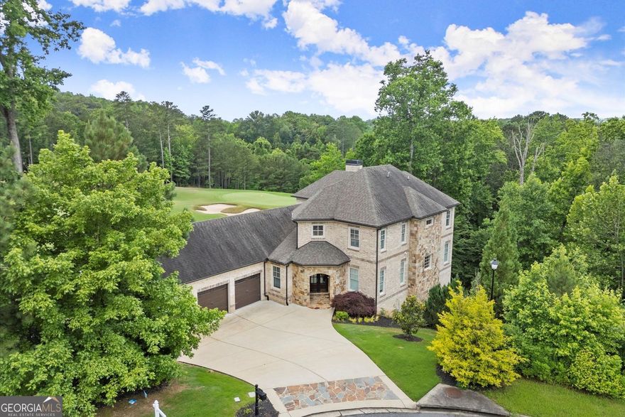 Set on a 1-acre lot amidst lush conservation areas, this custom-designed 5-bedroom, 4.5-bath home boasts stunning views and exceptional craftsmanship. The impressive 4 side brick and stone exterior is highlighted by custom double wood French doors. Soaring 12-foot ceilings, hardwood floors, freshly painted walls, and upgraded light fixtures throughout. The gourmet kitchen is a chef's dream, equipped with a large island, premium JennAir appliances, a farmhouse sink, soft close drawers and doors and a custom walk-in pantry. The main-level master suite provides a private sanctuary with double vanities, a spa-like shower, and a custom closet. Upstairs, three additional bedrooms, including a second master suite with a soaking tub, walk-in closet, and dual vanities. The expansive two-story basement with 12 and 19 foot ceilings is filled with natural light and features energy-efficient spray foam insulation, providing endless opportunities for customization. A three-car garage adds to the home's exceptional features. The beautifully landscaped two-level backyard offers a private escape, with the lower section recently cleared of trees for an open, inviting space. The backyard also features a newer retention wall and irrigation system. Echelon, a gated luxury golf community in Alpharetta, GA-known as "Atlanta's High Country Estates"-offers expansive homes on large lots, a premier golf course, a clubhouse, and breathtaking views of rolling hills and serene lakes. Residents enjoy top-rated schools, fine dining, and shopping, all while being just a short drive from the vibrant heart of Alpharetta and Milton.