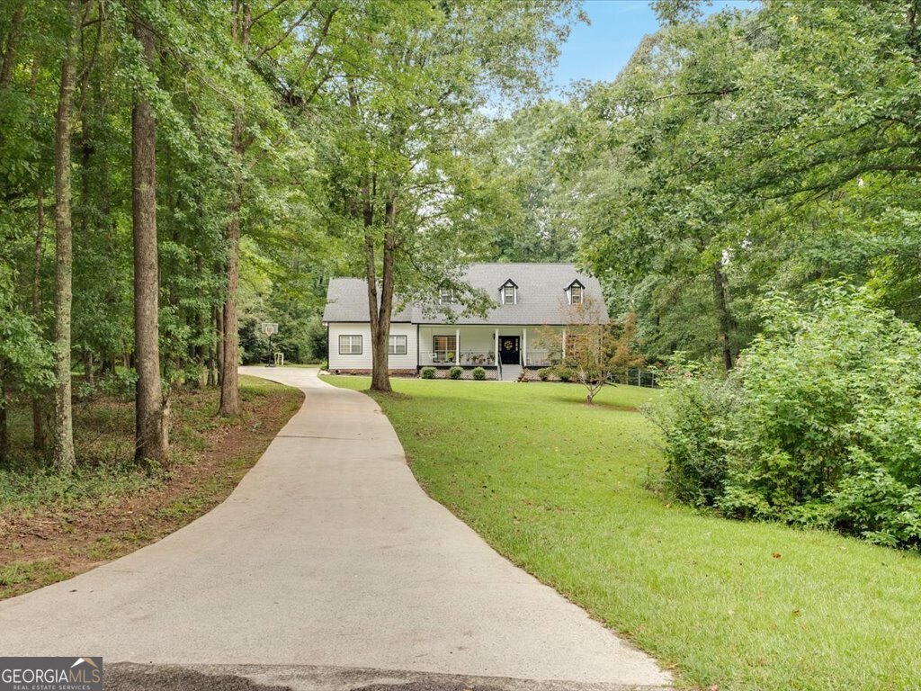 Welcome to your dream home in the highly sought-after Williamson Woods subdivision! Nestled on a sprawling 3.41-acre lot, this stunning 5-bedroom, 3-bathroom residence offers 3,145 SQ FT of beautifully designed living space. From the moment you arrive, you'll be captivated by the expansive front yard, long private driveway, and an inviting front porch-the perfect spot for morning coffee or relaxing evenings. Step inside to find a warm and welcoming family room with a cozy fireplace, ideal for gathering with loved ones. The main level features a spacious kitchen with ample counter and cabinet space, an eat-in breakfast area, and a separate dining room that comfortably seats 6-8 guests-perfect for hosting dinner parties. The primary suite, along with two additional bedrooms and two bathrooms, is conveniently located on the main floor. One of the true highlights of the home is the sunroom-a bright and versatile space that's ideal for your home gym, plant collection, or simply soaking in the natural light. Upstairs, you'll find two more generously sized bedrooms, a full bathroom, and a flexible bonus area that can serve as a game room, home office, or media space. Step outside to the peaceful and private backyard, where you'll enjoy quiet evenings around the fire pit or entertaining guests in the open space. A new shed added in 2023 offers even more storage and functionality. This property is a rare blend of space, comfort, and tranquility-don't miss your chance to make it yours! Recent exterior and energy efficiency upgrades! All-new primed Hardie Board siding installed and professionally painted in 2024-comes with a 30-year non-prorated warranty for peace of mind. The attic insulation was completely removed and replaced, improving energy efficiency and comfort year-round. These updates add lasting value and durability to the home!