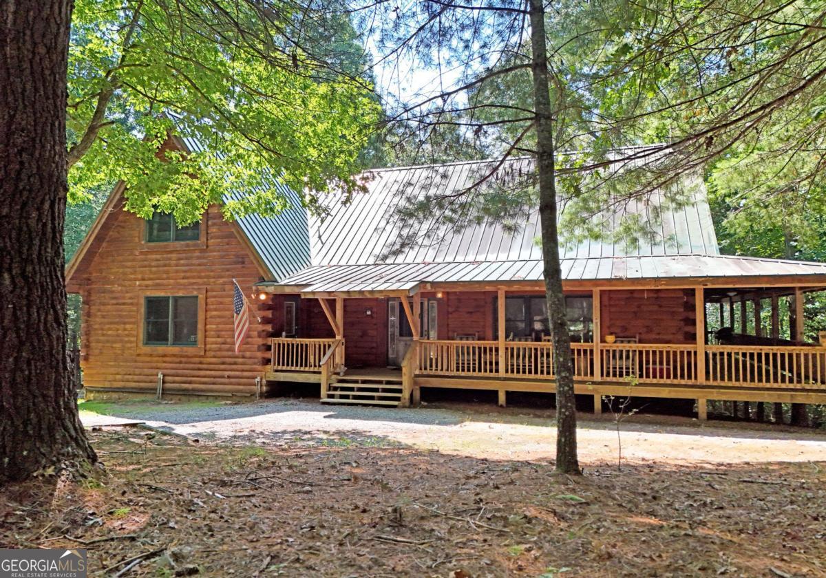 BIG BEAUTIFUL LOG HOME. Over 5400 sq ft including bsmt. 4BR/2.5BA featuring Open Great room with exposed beams, wood burning fplc w/ gas starter, Oak floors, dining area seating for Large table. The kitchen offers an oversized Central island with propane cooktop. Wall oven, wall micro, d/w and fridge. Built in desk and work station. 2 BRs on the main which includes the primary bedroom. Full bath has jetted tub, sep shower, dbl van, bayed feature window . Large walk-in closet. There is a mudroom which has a large bank of cabinets and storage. Upstairs features a large loft overlooking the great room and dining area. 2 spacious bedrooms have vaulted ceilings with exposed beams. Full bath. Full unfinished basement that is stubbed and rough wired, plumbed for a full bath, and has 2 car parking. The entrance porch is a 3/4 wrapped covered porch offering multiple areas for outdoor seating. Gentle 2 acre yard scattered with trees, fire pit area, wood storage shed. Close to Lake Nottely boat ramp off Lake Cove Lodge Rd. Approx 10 miles to town.