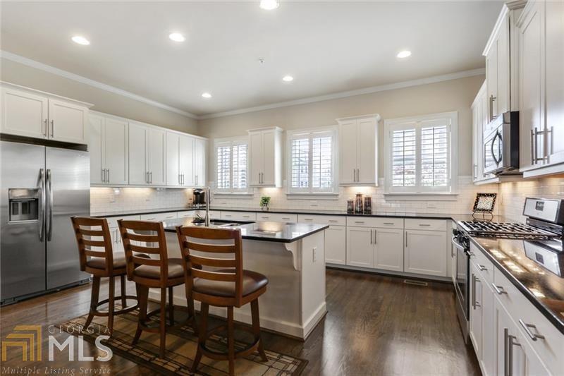 Immaculate Townhome minutes to Marta, Perimeter, and Mercedes Benz Corporate Office . This home features Two Large Bedrooms Upstairs and One large Bedroom on the Lower Level. All Bedrooms have Custom Closets. Huge Great Room with 10 foot ceilings, Crown Molding, Beautiful Hardwoods, Built-Ins next to Fireplace with Gas Logs and Custom Plantation Shutters.The Great Room opens up to a bright white kitchen with stone counter tops, Expansive Island, Subway tile and under counter lights. Large Open Living Area. Great for Entertaining. Real Hardwood floors and stairways. The generous deck is perfect for year around cookouts. This home also has a patio for separate outdoor living. Enjoy Metro living in a gated community.