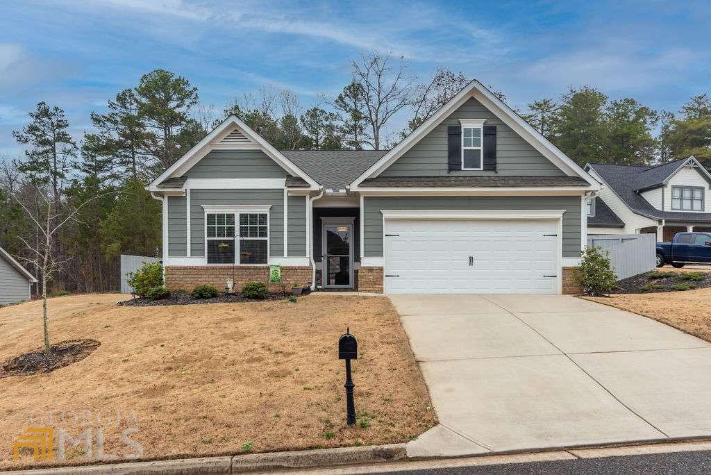 This pristine 3/2 ranch inside the Crown Pointe at Gold Creek subdivision shows like new! This property was built in 2019 and has been meticulously maintained by the original owner. The home boasts laminate flooring, crown molding, stainless appliances, kitchen island with granite counter tops, open living and dining areas, covered back porch, and upgraded fixtures. Spacious ownerCOs suite featuring separate soaking tub, tile shower, double vanity, and oversized closet that conveniently adjoins the laundry room. Fenced in backyard with plenty of usable space! Home is a short distance from Ga 400, North Ga mountains, wineries, downtown Dawsonville, Dahlonega, Cumming, and so much more!