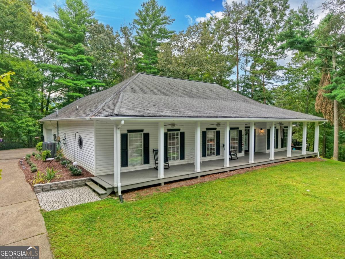 First Time On The Market! ONE LEVEL LIVING - Immaculate 3BR/2BA RANCH Home on a beautiful 0.76-acre lot in sought-after Buckhorn Estates! Enjoy living with no stairs to climb in this low-maintenance home; real wood floors, soaring 10' ceilings with beautiful custom trim work, and a cozy gas log fireplace in the living room. The well-designed floor plan offers a separate dining room, spacious kitchen with abundant cabinetry, tile countertops, and a breakfast nook. Split bedroom plan features a HUGE primary suite with spa-like bath including two double vanities (4 sinks total), oversized walk-in closet and a jetted tub/shower combo. The guest bath has a large tiled walk-in shower. Hallways have built in cabinetry provided great storage! Outdoor living shines with a lovely full length front porch and an inviting back patio with an OUTDOOR FIREPLACE-perfect for gatherings! FENCED backyard keeps pets safe and protects your garden from the abundance of wildlife in the community. 2-car GARAGE with ample storage. This home in in meticulous condition throughout. Feels like a true Southern Living home! You'll love living in this community-paved roads, high-speed internet, private well, Whitepath Golf Course (public), county-owned river park (great for daily walks and frisbee with your furbabies), fishing lake, and close proximity to Cress Creek Farm Store, Roo Vineyards, and the Ellijay Mushroom Farm Store. Conveniently located just 15 minutes to Ellijay and 20 minutes to Blue Ridge. Low HOA/POA fee of $225 per year. (The estimated property tax for full time resident, 65 yrs or older, is less than $600 per yr!)