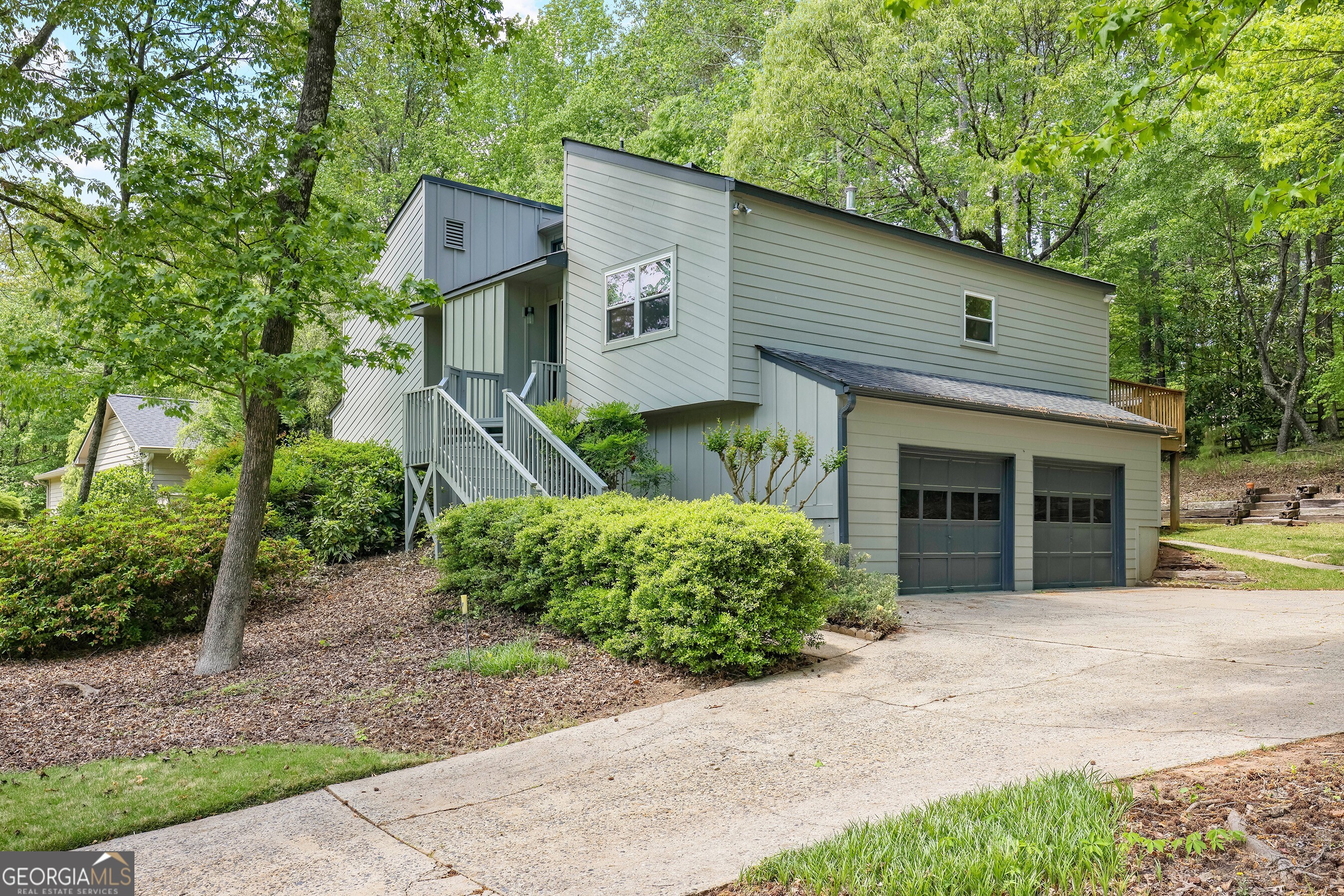 Charming Cedar Contemporary in Coveted Chimney Springs. Welcome to this beautiful 4-bedroom, 2-bath cedar contemporary nestled in one of East Cobb's most beloved neighborhoods Chimney Springs. With Hardi Plank siding offering a low-maintenance exterior and mature azaleas bursting with seasonal color, this home delivers both curb appeal and low maintenance. Inside, you'll find brand-new hardwood floors that flow throughout the main living areas, including a thoughtfully updated kitchen featuring double ovens, a modern vent hood, new stainless appliances, quartz counters, and a rolling island for added versatility. A sliding glass door off the kitchen opens onto a spacious back deck, where you can enjoy serene views of your private, wooded backyard. The heart of the home is the expansive family room, complete with soaring cathedral ceilings, a cozy fireplace, and transom windows that flood the space with natural light. Entertain effortlessly with a wet bar and direct access to the back deck. The formal dining room, just off the foyer with an expanded doorway, accommodates large gatherings perfect for hosting up to 25 guests during holidays and special events. Upstairs, the owner's suite is a private retreat with a large walk-in closet and private deck access overlooking the backyard. The ensuite bath features a partially updated design with a separate stone and glass surround shower. The lower level offers two additional guest bedrooms and a full guest bath, while the lowest level boasts a flexible fourth bedroom ideal as a media room, home office, or private guest space. Living in Chimney Springs means enjoying a lifestyle enriched with outstanding community amenities, including an Olympic-sized swimming pool, clubhouse, tennis, pickleball, and basketball courts, a lake with scenic trails, playground, and a large open field perfect for team sports and outdoor fun. With its thoughtful updates, functional layout, and access to resort-style amenities, this Chimney Springs gem is ready to welcome you home.