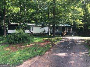 Mobile home on permanent foundation with a basement! Huge Family Room. Wood Floors . Updated kitchen with beautiful cabinets, granite countertops, Stainless Appliances. Bathrooms updated. Bonus room could be 4th bedroom (no closet). Separate Laundry Room. Outbuilding. Metal Roof. So many upgrades and lots of square footage.