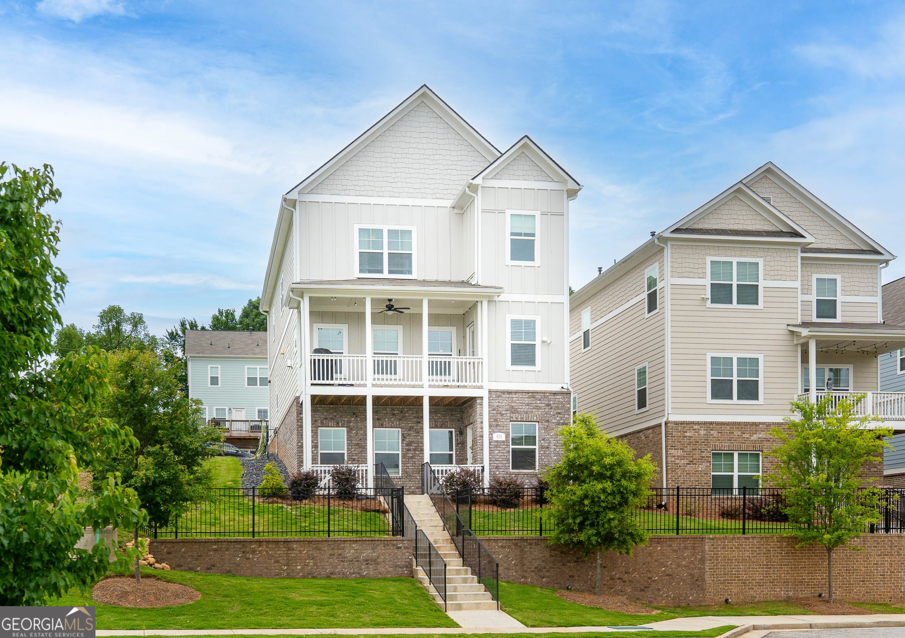 Welcome to this exceptional 4-bedroom, 4-bathroom home in the highly coveted Marvelle neighborhood Winner of the 2020 Obie Award for Community of the Year. Built in 2022, this residence blends timeless design with modern luxury in one of Marietta's most desirable locations.From the moment you arrive, you'll be captivated by the home's charming curb appeal, three full stories of elegance, featuring two covered porches perfect for entertaining or unwinding after a long day with views of the community and picturesque Kennesaw Mountain in the background. There is a spacious 2-car garage with an EV charging station, and a private fenced yard. This home boasts one of the largest lots in the community.Step inside to discover a bright, open-concept floor plan with soaring ceilings, upgraded hardwood floors throughout, and abundant natural light. The heart of the home is the elegant great room, complete with a cozy fireplace framed by custom glass cabinetry and topped with a Framed Art Smart TV a seamless blend of comfort and sophistication.The adjacent chef's kitchen is a dream, showcasing upgraded quartz countertops, a large island, stainless steel appliances, vented microwave oven, a pantry, and modern designer lighting ideal for both everyday living and hosting gatherings.A fully finished daylight basement adds flexible space with a private bedroom, full bath, and multi-use living area with one acoustic wall perfect for a home office, gym, guest suite, or media room. It's already equipped with a 220V stove outlet, and ready for a refrigerator and sink to create a kitchenette or bar.Upstairs, enjoy a bright loft space, two spacious secondary bedrooms, and a luxurious primary suite with dual vanities, quartz countertops, a dressing area, and a separate shower. The laundry room is conveniently located upstairs and has built-in cabinets. Additional highlights include: Elegant iron staircase balustrades, 13 CAT 6 lines added throughout for modern connectivity, SMART thermostats and additional electric outlets for mounted TV's. There is also Guest Parking in Front of the home. Unbeatable location: Minutes from I-75, Cobb Parkway, Marietta Square, and Truist Park.