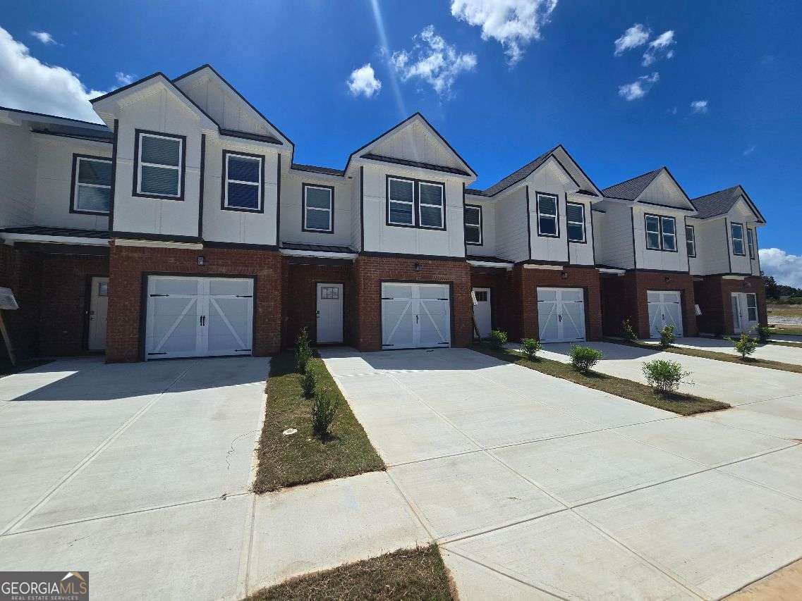 (PRICE IMPROVEMENT !!) NEW START COMMUNITY! NOW IS THE TIME TO RICHLY BUILD EQUITY$$.. NEW LUXURY TOWNHOME POOL COMMUNITY! ASK ABOUT 4.99% 30 Year FIXED RATES! ..Buyers Incentives $15,000! & MOVE IN FULL APLIANCES PKG Limited Time ONLY. Welcome to the Highly sought after Pool Community, The Grove at Mundy Mill located in beautiful Gainesville, Georgia. This community is Minutes away from LAKE LANIER, Downtown Gainesville, Major HWY, Major shopping venues, like Sams Club, Walmart, lots of restaurants, and five minutes away from The UNIVERSITY of NORTH GEORGIA. Also, community is located in a Good School district! THE JASMINE floor plan enables you to experience that elevated lifestyle. It shows off 3 Spacious Bedrooms with the Owner Suite having a sitting room area, SMART FAN in ceiling. The Owners Suite Bathroom gives off that HIGH END experience, which shows off SOFT CLOSE CABINETS, SMART TOILET, LED MIRRORS with WIFI, VESSEL BASIN SINKS, STAND ALONE TUB, TILED SHOWER WITH BENCH, and much More! All Secondary Bathroom have premium Granite countertops and RAIN HEAD SHOWER, The main level is Open and Spacious. The Kitchen area which faces the family room is spacious and has a large granite Island with Cup Washer, pull down faucet, and Pendant Lights and tons of cabinet space. The Family room is so inviting with a decorative recessed Fireplace, Smart Fan. All Townhomes have FULL BLINDS throughout home and are Smart Homes having Smart Home Panel, Smart Thermostat, and a UV HVAC system which is an advance air purification solution designed to improve indoor air quality. Also, to mention ALL Garages are Pre-Wired for EV CHARGING STATIONS for those homeowners that own Electric Cars! .. For More Information call Errol Gunnz ...( Completion of this Townhome is estimated End of JULY ) Photos are a representation only.-Lot 170