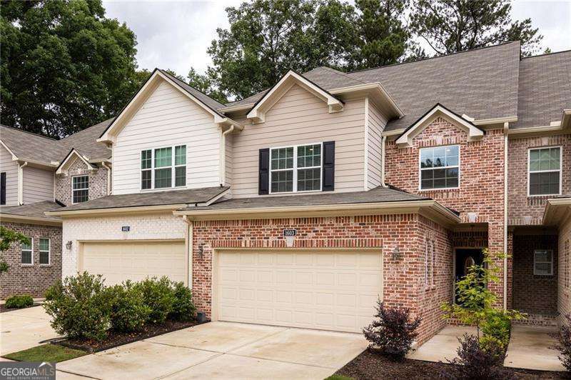 Tucked inside a quiet, gated community in Marietta, this newer construction home delivers the perfect mix of comfort, convenience, and calm. Just minutes from the charm of Marietta Square, the location makes everyday life easy without sacrificing peace and privacy. Step inside to warm hardwood floors and an open main level that feels spacious and welcoming. The living room centers around a cozy fireplace and flows effortlessly into the kitchen and dining area, creating a space that's just as great for relaxing as it is for hosting. The kitchen is the heart of the home, featuring a large central island, stainless steel appliances, granite countertops, gas range, and abundant cabinetry to keep everything within reach yet out of sight. French doors off the dining area lead to a private patio surrounded by lush greenery, giving you that tucked-away, treehouse feel. Whether it's coffee in the morning or wine in the evening, this space is made for slowing down. Upstairs, you'll find two generously sized guest bedrooms, a full bathroom, and a laundry room that keeps chores contained. The oversized primary suite is a true retreat with space to unwind, a large walk-in closet, and a spa-inspired bathroom with double vanity, walk-in shower, and separate water closet. There's more to love; the huge unfinished basement is already stubbed for a bathroom and ready for whatever you need next, think home gym, guest suite, office, or media room. Enjoy socializing with neighbors at the community pool and let the pups run free at the dog park. Conveniently located near I-75, this one checks all of the boxes and then some!