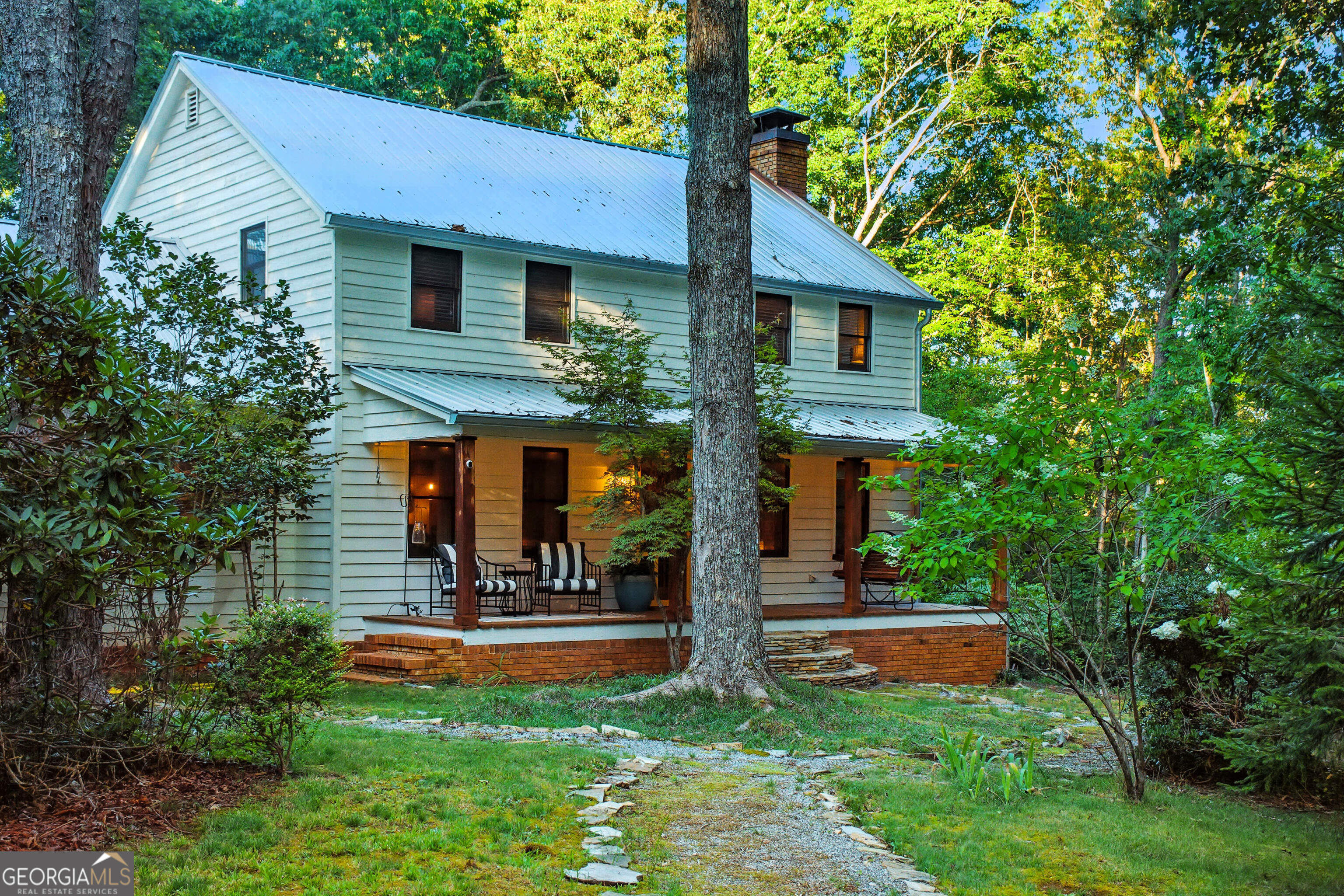 Welcome to 181 Gilreath Way in picturesque Dahlonega, GA! This completely renovated 3-bedroom, 3-bath home sits on 11.43 private, gated acres with a second building site-perfect for a family compound or guest home. Priced below appraisal, this property combines modern comfort with serene mountain living. Step inside to a bright, inviting living room featuring a whitewashed brick fireplace with a rustic wood mantle, large windows bringing in natural light, and a cozy, open layout perfect for gatherings. The chef-inspired kitchen showcases granite countertops, two-tone cabinetry (white uppers and deep green lowers), stainless steel appliances, a gas range, and a charming window over the sink that frames peaceful woodland views. Outdoor living shines with a screened porch, covered deck with glass garage door, and a spectacular fenced backyard oasis featuring a plunge pool, hot tub, and fire pit-ideal for relaxing or entertaining under the stars. Additional recent improvements include a pole barn (2023), brand-new electrical panel (2025), and a whole-house generator (2022). The property includes a creative "she shed," a 2-car garage, and essential utilities with well and electric. Enjoy seasonal mountain views, sunrises and sunsets, and private, serene living with no HOA-all just minutes from downtown Dahlonega, the University, shopping, hiking trails, waterfalls, and rivers. Whether you're looking for a primary residence, Airbnb investment, or mountain retreat, this property has it all.