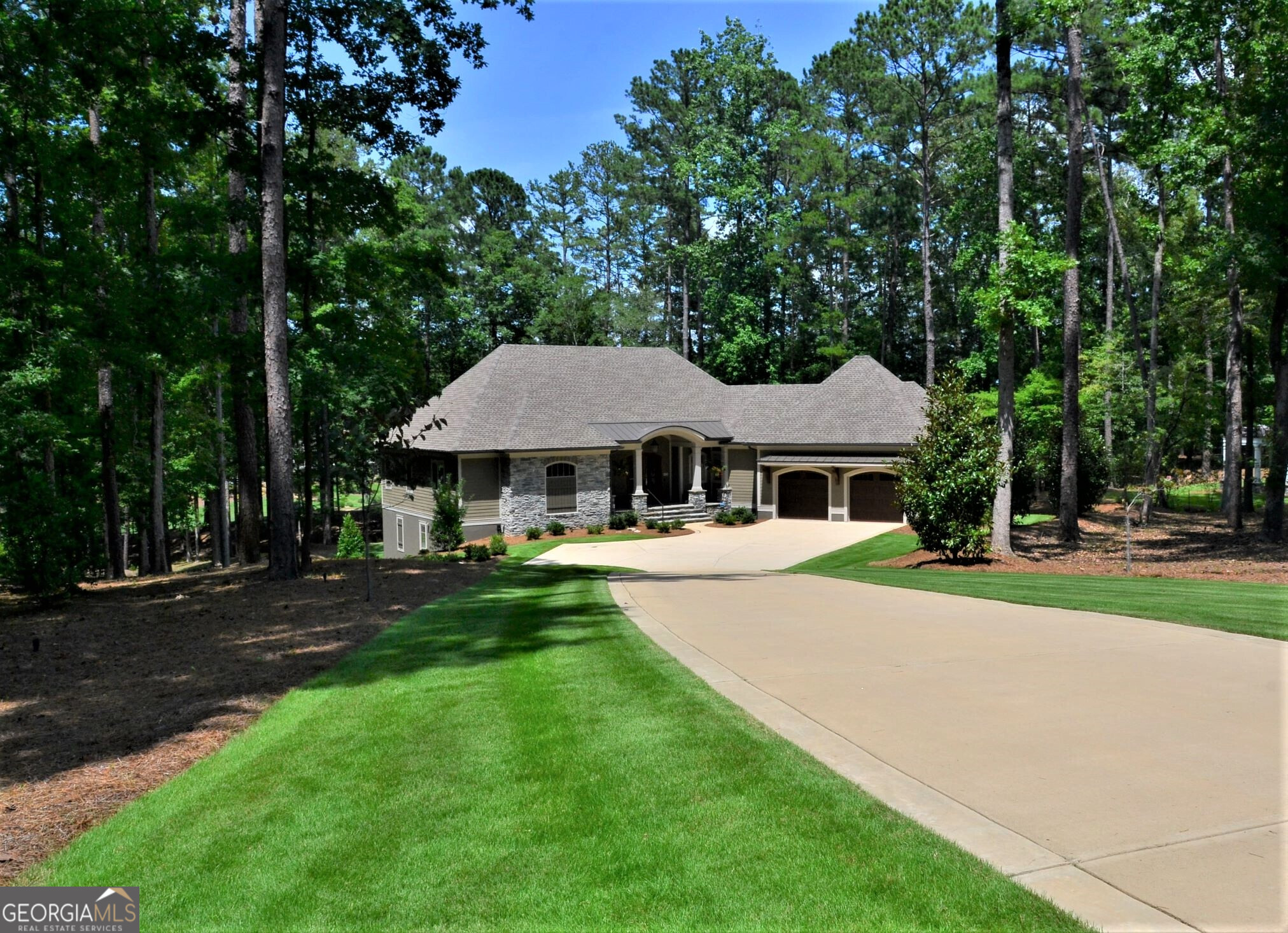 With beautiful lake views, this home is located in the sought after Jackson Ridge Subdivision of Reynolds at Lake Oconee. Situated on 1.13 wooded acres, with picturesque lake and golf views, this immaculate residence will please the most discerning buyer. Completed in December of 2020 by Dreambuilt, this custom home is unique and open, featuring oversized rooms, all with stunning views. Guests will be impressed by the large great room with 12 ft. coffered ceilings, and spacious open floor plan. The extra-large adjoining four season porch also features 12 ft. beamed ceilings and shiplap walls, overlooking the lake and 2nd fairway of the National Cove Course. The spacious chef's kitchen is an entertainer's dream, showcasing high-end stainless steel appliances including a 48 inch professional dual fuel range with 6 gas burners, griddle and two electric ovens, as well as two combined, extra-wide 64 inch Professional Refrigerator/Freezer. Quartz Countertops span the kitchen with a huge, Quartz center island that offers a space for guests to gather. The island adds to the more than ample storage in this home. Crisp, white custom cabinetry and under cabinet LED Lighting complement the rich gray custom center island. Soft close doors and drawers make working in this kitchen a pleasure. An Andersen custom glass door leading to the grilling deck, complete with gas grill and gas hook up, make it perfect for entertaining with ease. This is also a great place for a quiet cup of coffee and tea in the morning overlooking the lake! Festive dinners will be held in the beautiful large dining room with vaulted ceiling, also with lake views from the wall of windows. The Crystal Chandelier complete with Swarovski Crystals add to the specialness of this room. A brand new dry bar was just added to the great room with a 51 bottle, wine (beverage) cooler, ample storage with four custom cabinets. Privacy and relaxation are yours in the Primary Suite with a large Primary Bath and Walk in custom Closet. The Primary bath features an oversized soaking tub, large custom, glass shower, and dual vanities on opposite sides of the room. The Custom Walk-in closet provides plenty of room for all of your apparel. Guests will enjoy their own private oasis on the walkout terrace level all with ensuite bathrooms and generously sized bedrooms and closets. A second great room with wet bar and full sized refrigerator/freezer and their own private laundry room. Leading off of the terrace level great room is a large, gorgeous, tiled, covered patio, complete with new outdoor TV, 10 ft. cedar ceilings, and huge impressive stoned pillars, overlooking the manicured back yard and golf course. Tons of storage is found in the kitchen, home center, and additional 647 sq. ft. of storage area on the terrace level. This home is also equipped with Ecobee Thermostats, making it easy to set all your thermostats remotely while you are away. Four separate HVAC Systems help to maximize efficiency and minimize heating and air conditioning costs, as well as spray foam insulation in the ceilings. Included are whole house water softener, Reverse Osmosis Taps in both kitchens, along with a hot water recirculating pump. There is a separate irrigation system water meter featured in this house to help reduce water bills. Andersen Energy Efficient Casement Windows are not merely beautiful, but also help to reduce heating and air conditioning bills. Jackson Ridge is a quiet, elite section of the gated Reynolds at Lake Oconee, featuring homes on this street up to seven plus million dollars. Close to the National Tavern, or take a 4 min. drive to the Linger Longer Marina and have your rental pontoon awaiting you at the dock for a day on the lake. Only minutes away from the Ritz Carlton Lake Oconee. Only 4 and one half years old, this meticulous home is better than new, and truly move in ready. Club Membership is available to buyer on this home.