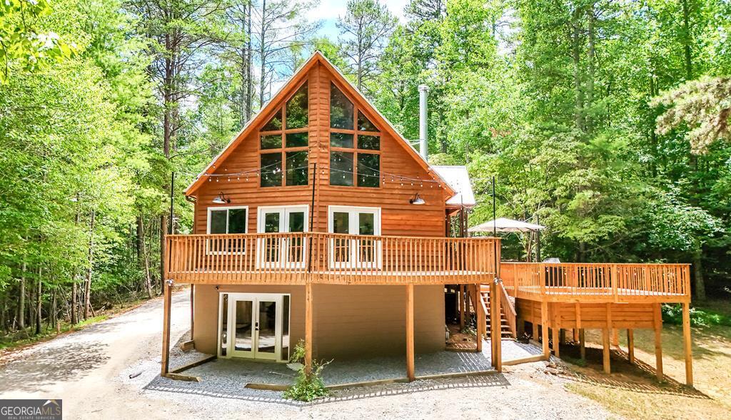 ? Chalet-Style Mountain Retreat on 2.77 Acres ? Discover this fully renovated 6-bedroom, 3-bathroom chalet-style home, nestled on 2.77 private acres and surrounded by the beauty of nature. Thoughtfully updated from top to bottom, this property blends rustic charm with modern luxury - making it the perfect full-time residence, vacation home, or income-producing rental. Step inside to soaring cedar ceilings and a spacious open layout that's bathed in natural light through the iconic floor-to-ceiling living room windows. With two brand-new full kitchens, this home is designed for large gatherings, extended stays, or multi-family living. Every detail has been upgraded - from the new roof, high-efficiency heat pump systems, water softener, 400-amp electrical rewire, windows (with the exception of the floor to ceiling windows in the living room), and doors - giving you peace of mind for years to come. Outdoors, the entertainment options are endless. Enjoy a brand-new deck with a private hot tub, plus a custom firepit with stadium-style seating - all surrounded by serene wooded views. A newly installed parking pad with EV charging adds modern convenience to this mountain escape. Located just 25 minutes to Blue Ridge and Murphy, NC, and 20 minutes to McCaysville, you'll be close to dining, shopping, and outdoor adventure, while still enjoying a tranquil, private setting. Whether you're seeking a personal mountain getaway or a ready-to-go vacation rental, this stunning chalet offers it all.