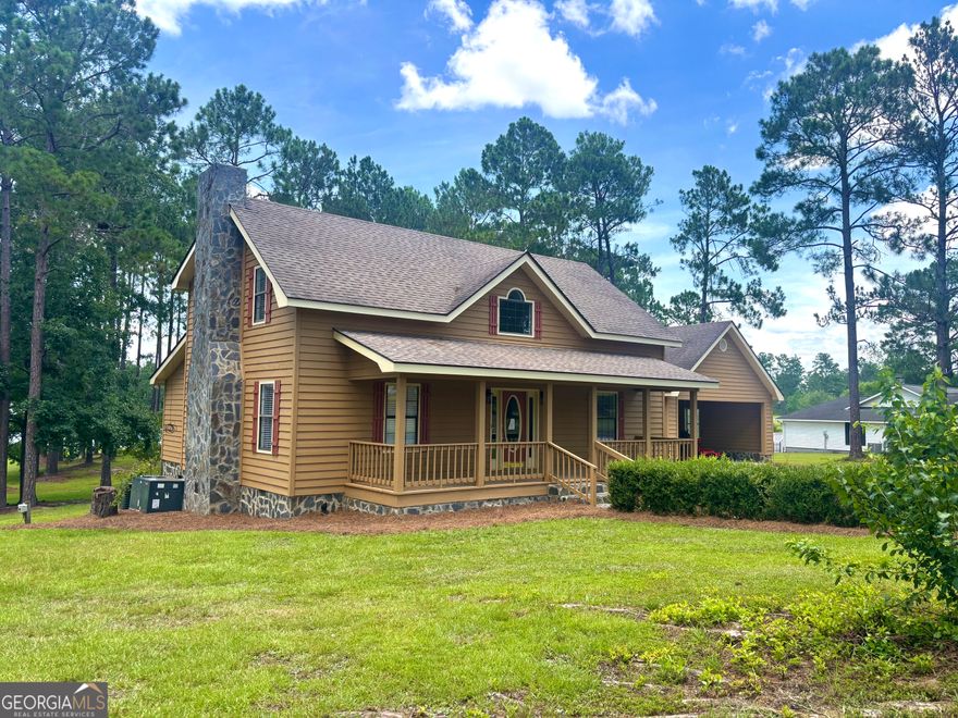 Discover lakefront living at its finest at Whatley Vineyards in McRae-Helena, GA. This beautifully remodeled cedar-sided home sits on a spacious corner lot with breathtaking lake views. The property features a covered dock, a large back deck with access to the kitchen and carport, and a heated and cooled workshop in the basement. The double carport includes ample storage space, perfect for seasonal or recreational items. Step onto the inviting spacious front porch and enter through the foyer, where a large living room with exposed beams and a stunning fireplace centerpiece will greet you. The open layout flows seamlessly into the dining area, which overlooks the serene lake through double windows. The kitchen boasts granite countertops, an abundance of cabinetry, an island with a downdraft cooktop, and a wall oven and microwave. A convenient half bath is located off the foyer, and the adjacent laundry room offers excellent cabinet space and access to the garage. The main-floor primary bedroom is a luxurious retreat featuring a double vanity with makeup space, a walk-in closet, and a sunken tub-shower combo. Upstairs, two generously sized bedrooms share a thoughtfully designed bathroom with dual vanities in separate rooms and a tub-shower combo accessible from both bedrooms and the hallway. The hallway also includes two large storage spaces, ideal for seasonal items. Every one needs a workshop! The workshop is located under the home and is heated and cooled. Access to the crawl space is located here. This home is designed for comfort and entertaining, with picture windows showcasing panoramic lake views and outdoor spaces that invite relaxation. Don't miss your chance to own this incredible lakefront property with 3 ponds access on this great fishing lake.