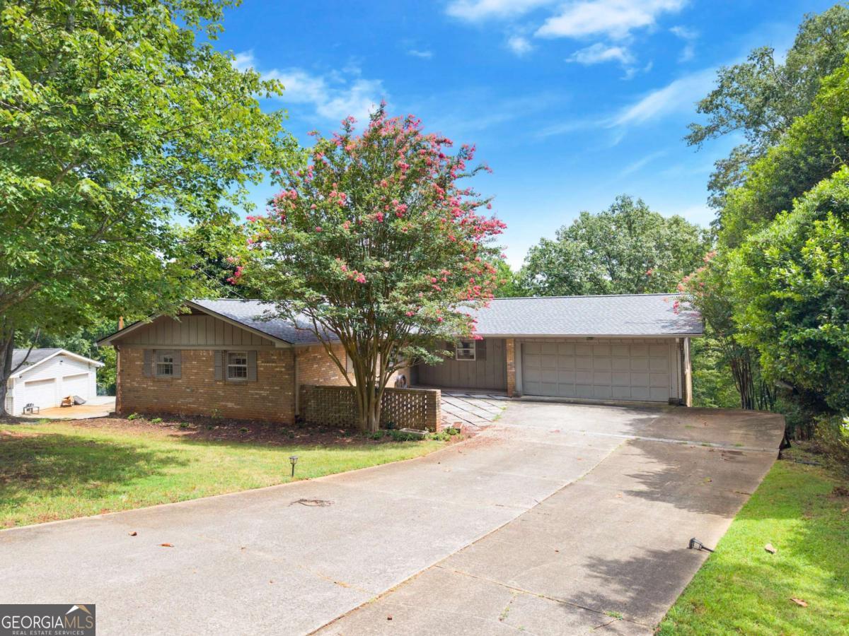 BRAND NEW ROOF - July 2025! Timeless 4-sided brick ranch located in the highly sought-after 30501 zip code, brimming with personality and opportunity. Ask me about a great renovation loan that would work perfectly for this property! Offering a spacious and versatile floor plan, this home features 4 bedrooms and original hardwood flooring that adds warmth and character throughout. The thoughtfully designed main level offers an abundance of natural light. The kitchen showcases beautiful marble countertops and updated appliances. With two fireplaces, one on the main level and another in the basement, you'll enjoy cozy living spaces year-round. The finished basement adds endless possibilities, from a second living area to a home office or in-law suite. Sitting on a nearly one-acre level lot, the backyard is perfect for playing football or fetch and offers ample room for outdoor activities and your landscaping vision. The charming front courtyard patio invites you to relax with a morning coffee or greet guests in style. Completing the home is a 2-car garage and extended parking pad for convenience and storage. This home is packed with potential, just waiting for your dream to transform it into something truly spectacular.