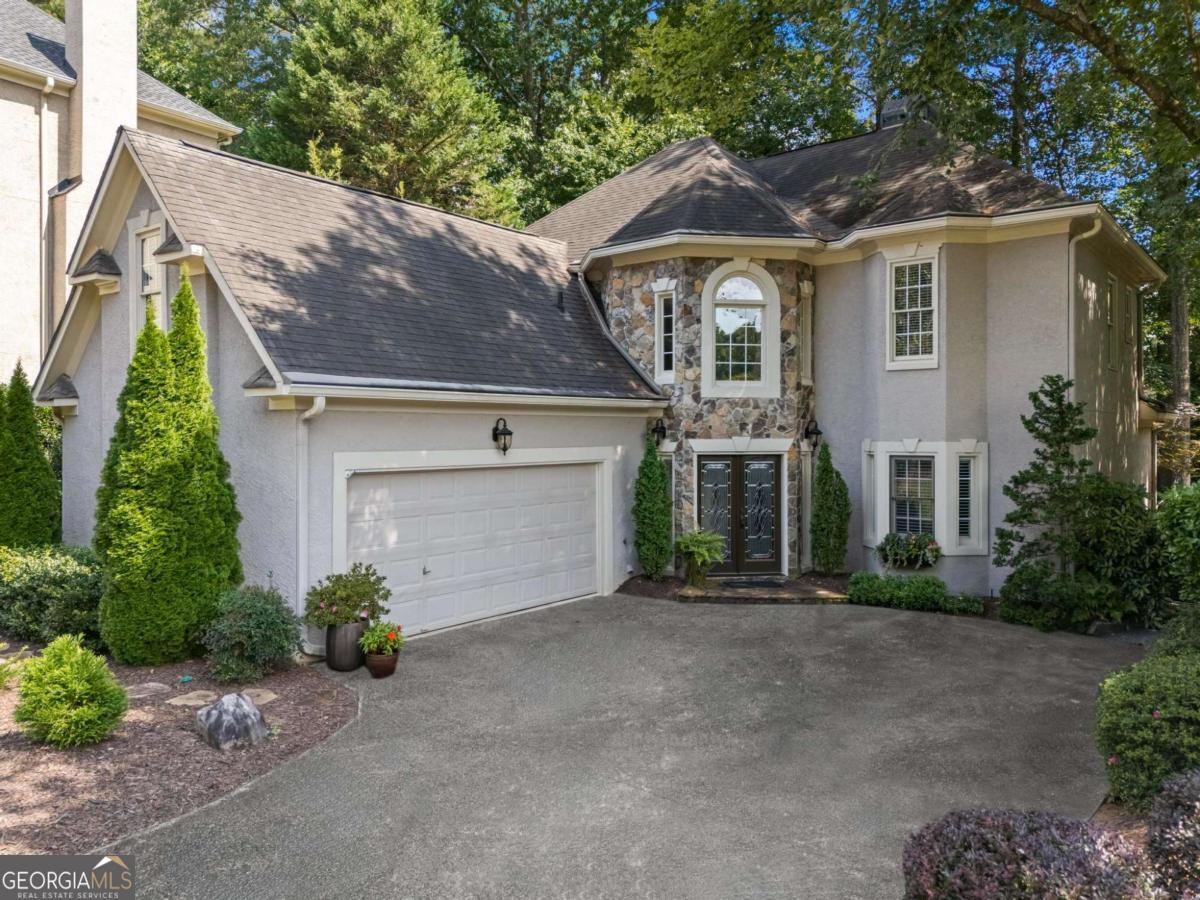 Enjoy refined living with minimal upkeep in this thoughtfully designed home tucked into a quiet cul-de-sac in Towne Lake Hills East, with a view of the 11th hole just outside your driveway. With its smart layout, modern upgrades, and timeless finishes, this residence offers comfort, flexibility, and elegance at every turn. The main level features a spacious primary suite tucked at the back of the home, complete with dual walk-in closets, a spa-style soaking tub with jets, a separate shower, and elegant plantation shutters. Large windows throughout fill the home with natural light, making each room feel bright and open, as if you're outdoors without ever stepping outside. At the heart of the home is a beautifully remodeled kitchen, designed with style, elegance, and ease in mind. Granite countertops, under-cabinet lighting, upgraded cabinetry, and all-new KitchenAid appliances (2023), including a 5-burner gas stove, make cooking and entertaining seamless. Thoughtful touches like a built-in spice rack and a lazy Susan add to the kitchen's functionality. A cozy breakfast nook is adjacent, while a separate formal dining room with bay windows makes hosting special meals a pleasure. Hardwood floors with a hand-scraped finish flow throughout the main level, while custom molding and a crafted staircase with oak treads add warmth and sophistication. The living room impresses with cathedral ceilings and a dramatic floor-to-ceiling stacked-stone fireplace (wood-burning with blower and smoke inhibitor) that becomes the centerpiece of gathering. From here, you step into a screened-in covered porch, overlooking a garden sanctuary complete with mature plantings, French drains, bridges, winding pea-gravel and slate walkways, and a full irrigation system to keep everything lush with ease. It truly becomes a retreat without heavy maintenance. Conveniently, the main level also includes laundry and a powder room, plus a garage with built-in storage plenty large for tools, seasonal gear, or hobby supplies. Upstairs, you'll find two large bedrooms, each with full baths and walk-in closets. But it's the oversized bonus room that really sets this home apart. Tucked privately over the garage and equipped with heating and air, this space is a blank canvas: home theater, gym, art studio, game room, or executive office, the possibilities are endless. Recent updates, including a new tankless water heater in 2023, the upstairs HVAC system replaced in 2022, and the terrace-level HVAC system in 2017, mean that many of the major systems are already taken care of. The neighborhood doesn't disappoint when it comes to amenities: Towne Lake Hills East offers swimming pools, tennis courts, playgrounds, and a common clubhouse space. Green spaces and walking paths are plentiful, allowing for leisurely strolls and outdoor enjoyment without having to travel far. Excellent schools, shopping, dining, and recreation are all nearby. If you're seeking a home that delivers comfort, character, and minimal upkeep without sacrificing space or style, this one checks all the boxes.