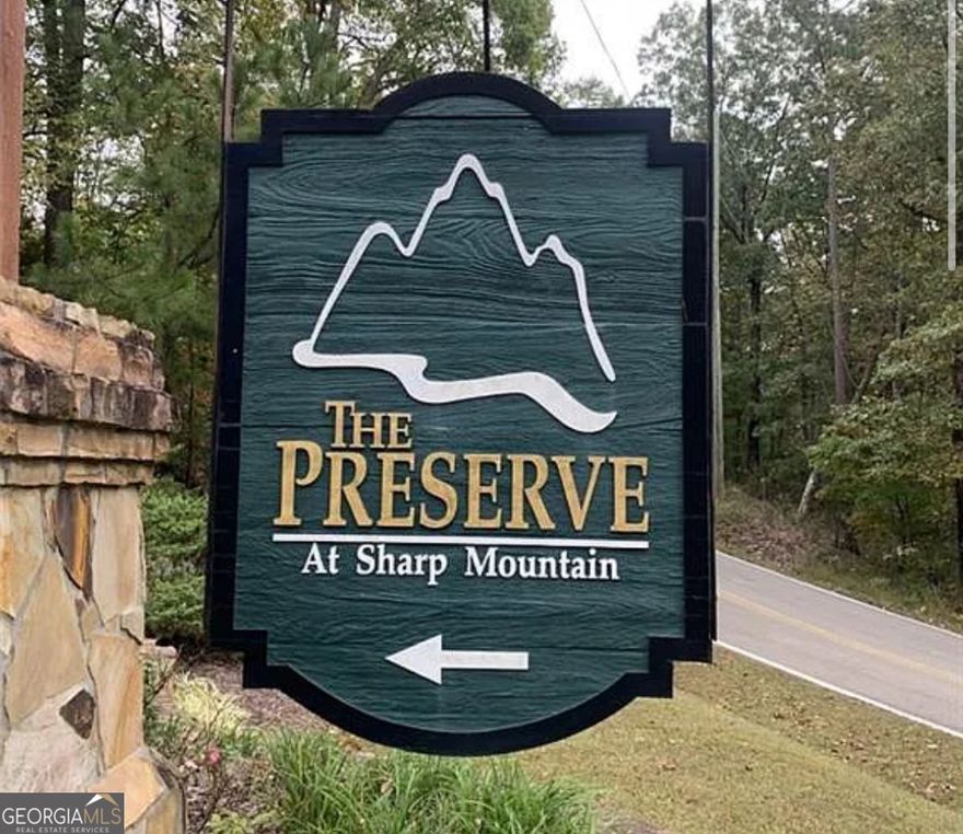 Build Your Dream Home in North Georgia's Hidden Gem only 1 hour outside of Atlanta    Seize the opportunity to own 3 pristine acres in the exclusive, gated community of The Preserve at Sharp Mountain. This serene lot is the perfect canvas for your custom-built home or a tranquil weekend retreat.    The driveway is already cleared, streamlining the building process. Bring your own builder and design a home that harmonizes with the natural beauty of the area. The community boasts paved roads, hiking trails, and abundant wildlife, ensuring peace and privacy.    Local Attractions in Jasper, GA:    Burnt Mountain Preserve Trail: Hike through a 900-acre preserve featuring wildflowers and scenic creek views.     Historic Sites: Explore the Old Pickens County Jail and the Griffeth-Pendley House, both listed on the National Register of Historic Places.     Gibbs Gardens: Stroll through 220 acres of botanical gardens, including themed areas like the Japanese Garden and Waterlily Garden.     Appalachian Trail Access: Embark on hikes along the southern terminus of the renowned Appalachian Trail.     Local Dining: Savor farm-to-table meals at 61 Main or enjoy fresh seafood at Last Catch.     Antique Shopping: Browse unique finds at the Mountainside Antique Mall.     Whether you're seeking a peaceful retreat or a place to call home, this lot offers the best of North Georgia living.