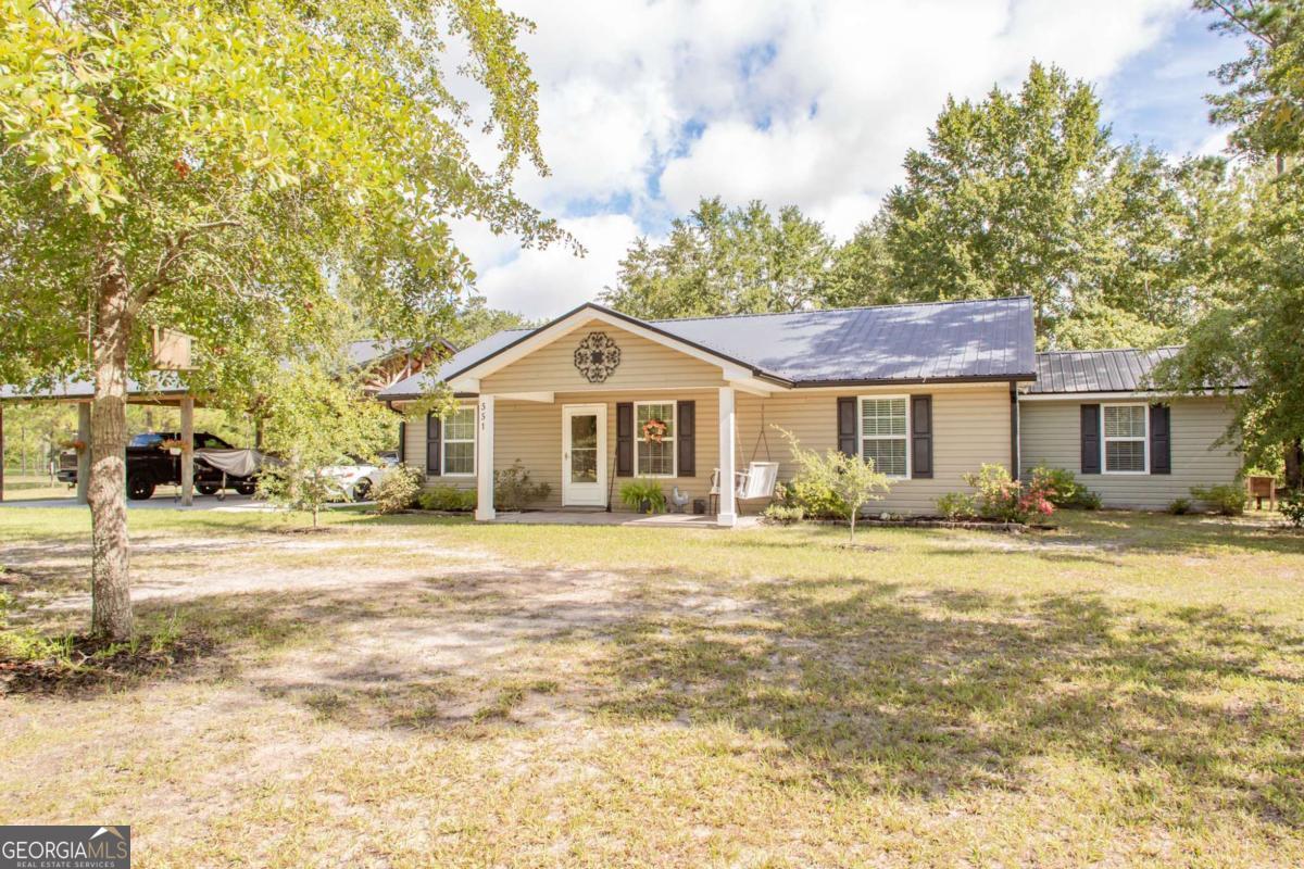 Welcome to your serene escape in the heart of Folkston! Nestled on three peaceful acres, this beautifully maintained 2-bedroom, 2-bath home offers comfort, space, and versatility. Built in 2016, the home features 1,672 square feet of thoughtfully designed living space-perfect for everyday living or a relaxing retreat. Step inside to a spacious open floor plan with modern finishes throughout. The well-equipped kitchen flows seamlessly into the living and dining areas, ideal for entertaining or cozy nights at home. The extra dining space can be easily changed to a third bedroom by adding a door to the entrance of that room. Outside, enjoy the expansive property with plenty of room to roam, garden, or simply take in the tranquil surroundings. The three-car paved carport provides ample parking, and the separate storage shed offers extra space for tools and gear. But that's not all-the shed also includes an air-conditioned bonus room, perfect as a game room, home office, studio, or guest space-the choice is yours! Conveniently located, this property is just a short drive to Jacksonville International Airport, making travel a breeze. Outdoor lovers will appreciate the nearby Okefenokee National Wildlife Refuge, offering world-class bird watching, kayaking, and nature trails. Plus, you're only a short drive away from the beaches and beautiful Georgia and Florida coasts, giving you the best of both peaceful country living and coastal convenience. Whether you're seeking a quiet homestead or a place to relax with easy access to nature and city amenities, this home delivers it all. Don't miss this unique opportunity!