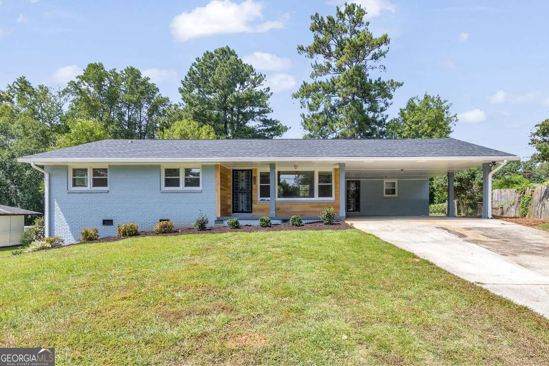 Completely renovated from top to bottom with permits, this 3 bed / 2.5 bath four-sided brick ranch blends timeless charm with modern upgrades. Every detail has been thoughtfully updated, including the roof, HVAC, water heater, plumbing, electrical, windows, cabinets, vanities, insulation, and both interior and exterior paint. Step inside to an open floor plan with beautiful hardwood floors throughout. The brand-new kitchen is a true showstopper, featuring quartz countertops, expansive island, a farmhouse sink, stainless steel appliances, and a spacious dining area with a stylish light fixture and accent wall. The primary suite offers a luxurious retreat with a chic double vanity and a lovely shower. Two secondary bedrooms share an updated bathroom, while a convenient powder room is available for guests.The unfinished basement is stubbed and ready to finish to your liking, providing endless possibilities for customization. Outside, enjoy the fenced backyard with a new deck, ideal for entertaining and spending time outdoors. Enjoy ample parking with a carport and drive-under garage. Conveniently located near shops, parks, dining, and easy access to Hwy 78 and I-285, this home is move-in ready and designed to impress.