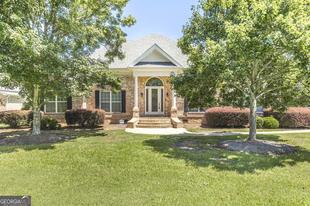 Discover a slice of suburban paradise at 213 Liberty Trce, Macon, GA. Nestled on a sprawling .9-acre lot, this stunning 5-bedroom, 4-bathroom brick masterpiece promises elegance and comfort. Step onto gorgeous hardwood floors that flow seamlessly through custom-trimmed spaces, highlighting an exquisite attention to detail. The main level boasts four spacious bedrooms, while the primary suite offers a unique office/nursery with direct access to a serene screened porch and inviting hot tub. The envy-inducing custom walk-in closet and a luxurious tile shower with dual showerheads add a touch of indulgence. Culinary enthusiasts will revel in the gourmet kitchen, featuring a hybrid range stove/oven and sleek stainless steel appliances. Upstairs, a versatile living area and bedroom, complete with a quaint kitchenette and a classic clawfoot tub, await. Unwind and entertain on the expansive 26x26 deck with a charming brick fireplace, set against a backdrop of lush greenery in your fenced backyard. Just 15 minutes from downtown Macon and Warner Robins AFB, this home is an oasis of tranquility and convenience.