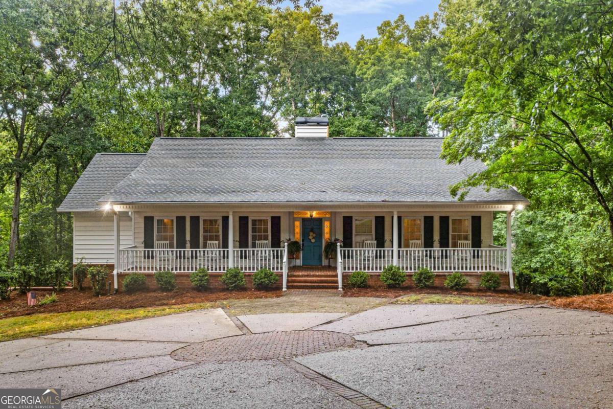 Welcome to this stunning 4-bedroom, 3-bath Ranch home on a beautifully finished terrace level that offers the perfect blend of southern charm and modern comfort with seasonal lake views and lake access! The inviting covered front porch, complete with rocking chairs, extends the full length of the home and sets the tone for relaxed living, just add a glass of sweet tea and enjoy these evening summer storms. Inside, the bright white kitchen features granite countertops and an abundance of cupboard space and natural light from windows throughout the home. The spacious vaulted family room, accented with wood beams, flows seamlessly with real hardwoods throughout the top floor. The spacious primary suite is conveniently located on the main level with a shiplap, updated primary bathroom and an amazing walk-in closet. Downstairs you'll also find 10 ft ceilings, a large spacious family room, 2 bedrooms and a full bath which can be great for family visitors. Bonuses include the expansive Trex deck off the kitchen which is perfect for outdoor gatherings, while the side-entry garage and large front parking pad offer plenty of parking options. This home has over $43K in updates and combines character, space, and functionality in a prime setting. Don't miss your chance to make it yours! The home is also centrally located to 3 public boat launches (Wahoo Park 2.6 miles, Thompson Bridge Park 2.3 miles and Holly Park 3.1 miles)