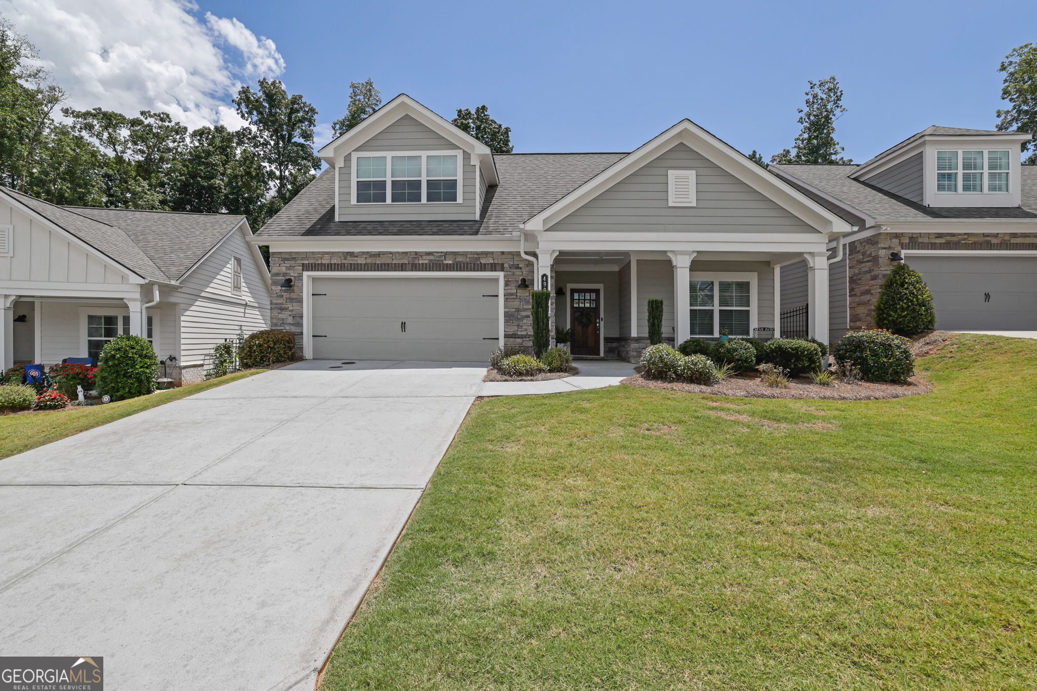 Welcome to effortless living in one of West Cobb's most desirable 55+ communities-The Courtyards at Camden. This impeccably cared-for home blends smart design with luxurious upgrades, offering a relaxed and low-maintenance lifestyle just minutes from Mars Hill, Stilesboro, Brookstone, and the Northwest YMCA. Inside, the spacious Promenade floor plan by Traton Homes showcases open-concept living with abundant natural light and elegant finishes throughout. Step from the charming front porch into a welcoming foyer that opens to a private guest bedroom and full bath-perfect for visitors or a quiet retreat. The heart of the home is the expansive great room featuring a cozy stone fireplace with built in cabinets, a dining area, and a chef-inspired kitchen outfitted with beautiful cabinetry, custom lighting, pull-out drawers, and a large pantry. Just off the kitchen, a versatile room with French doors is ideal for a home office. Adjacent to the kitchen and garage, is a large custom walk-in laundry room with built-in cabinetry and a laundry sink. The hall closet featuring a closet system adds valuable space for hobbies, seasonal items, or pantry overflow. Outside on the private side courtyard and you'll find an incredible outdoor living space designed for outdoor entertainment. Retreat to the expanded primary suite with ample space for a sitting area or reading nook, plus a spa-like en suite bathroom complete with a double vanity, a step less walk-in shower. A massive walk-in closet and stylish window treatments add to the comfort and appeal. With neutral tones, luxury vinyl plank flooring in the main living areas, plush carpet in the bedrooms, and thoughtful storage throughout, this home is move-in ready. Low monthly HOA dues of $270 include lawn care, termite bond, trash service, and full access to the community clubhouse, fitness center, pool, and dog park. Plus, Cobb County offers a fantastic school tax exemption for homeowners 62+-a major bonus!