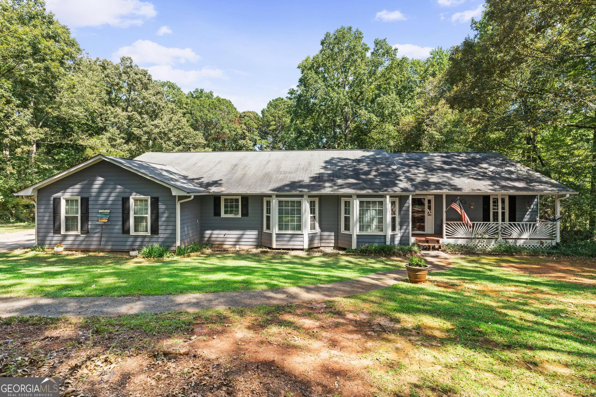 Welcome to this exceptional 5-bedroom, 3-bath ranch with a fully finished basement, nestled on a picturesque 1.8-acre lot in the desirable Briarwood subdivision of Henry County. With no HOA, this property offers freedom and privacy while boasting incredible outdoor living spaces that truly set it apart. From the charming covered front porch to the attached two-car garage, every detail invites you to relax and enjoy. The main level features a screened-in deck with ceiling fans, perfect for year-round enjoyment, while the basement level offers its own screened-in patio overlooking a fully fenced inground pool-an entertainer's dream. Inside, you're welcomed by a bright foyer that flows into a spacious family room with a cozy fireplace and two sets of double doors leading out to the deck. The formal dining room connects seamlessly to the kitchen, which offers abundant cabinetry, a breakfast area, and a nearby laundry room with built-in storage and deck access. The oversized primary suite is located on the main level and features a walk-in closet and an en suite bath with double vanities, a soaking tub, and a separate shower. Two additional bedrooms and a full bathroom complete the main floor. Downstairs, the finished basement provides a versatile living area with a kitchenette, two bedrooms, a full bath, and private access to the patio-perfect for an in-law suite, guest accommodations, or hobby and flex spaces. The home is thoughtfully equipped with two septic systems, one for each level, for added convenience. With its expansive lot, resort-style pool area, and multiple screened living spaces, this home offers a rare combination of comfort, functionality, and Southern charm.