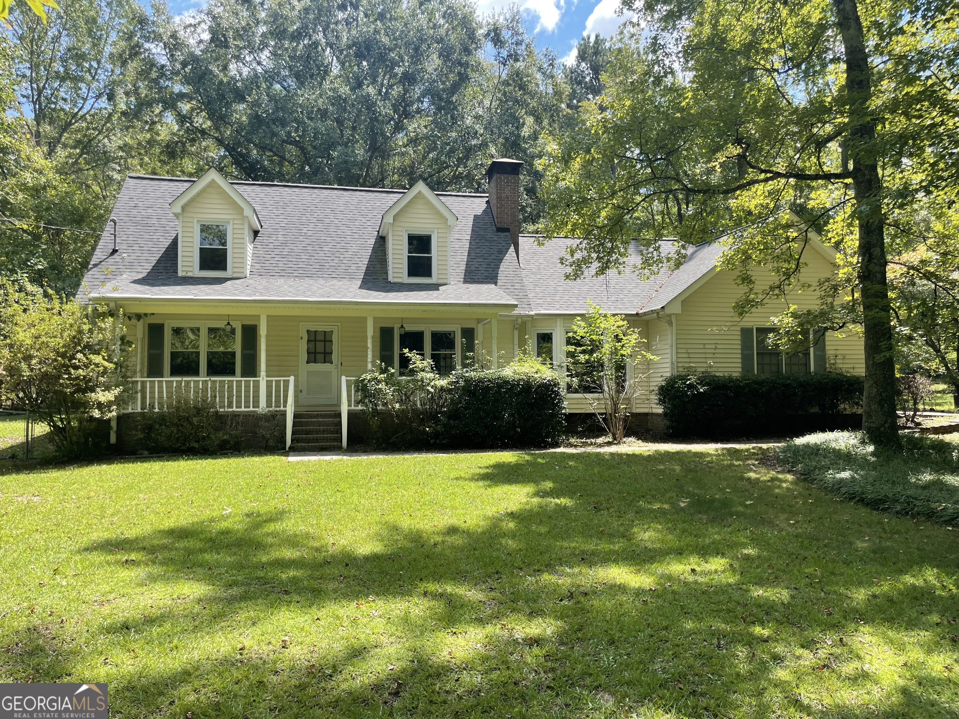 Great opportunity to own a private 5 acre fenced property in South Fayette County with pastures and a huge outbuilding in the Whitewater High school district Zoned AR. This spacious Cape Cod designed home has a large front yard off the road , an attached oversized 2 car garage with a storage room, a long covered front porch for lots of rocking chairs under the shade of the hardwood trees. When you enter the front door there is a large family room with a Buck stove in a stone fireplace, all real hardwood floors. Family room has a hall to the Primary Owners suite bedroom on the main floor also with real hardwoods and a walk in closet, Owners Suite bathroom has a separate shower and soaking tub. The family room also flows into a very large Kitchen with a center island with a smooth top, downdraft range oven, a second wall oven, microwave, dishwasher, solid surface countertops, tons of cabinetry and countertop space all around 3 sides of the kitchen, a built in desk area with glass door cabinets on the upper cabinetry , Stainless steel, double bowl, undermount sink, solid hardwood cabinetry all around for the uppers and lowers, tiled kitchen floor, tiled backsplash and tiled eat in area flooring, a bay window area, bumped out for additional seating / space in the eat in area. Kitchen has access to the mud room with tiled floors and a wash sink cabinet. The laundry area has an exterior door and door to the attached 2 car garage. The whole house interior walls have been freshly painted main floor and upstairs including all closets and bathrooms. The attached garage is kitchen level entry, oversized and has a storage room off the inside of the garage with auto garage opener. The main floor family room also has a rear door to the large, 4 season enclosed sun porch (not counted in the finished sf). Upstairs, there are two large oversized bedrooms with lots of windows and light and a full bath with tiled floors in between them in the hall. Their is an additional unfinished room not counted in the sf feet that has finished walls and ceilings that just needs carpet, paint and an a/c vent to be additional finished sf, if you wanted to finish or just easy storage area as it is. The home has a like new roof only 4 years young with 30 year architectural shingles. The 5 acres is all fenced with a lot of pasture and spare harwoods for some shade. Their is a large workshop with a super high ceiling and covered RV parking next to it. The workshop has a concrete floor with 200 amp separate breaker / power panel and its own electric power meter . This workshop is tall enough to house another RV fully enclosed or multiple cars or could be a barn for livestock ect.. Zoning department confirms you can have up to three horses and multiple livestock if you desire. There are also 2 additional storage buildings on the property. A separate fence separates the backyard from the pasture fence. Convenient location near Hwy 92 south for Fayetteville, Hampton, Woolsey or Griffin. Easy show on Supra. Use showingtime for an appt. or call Mark