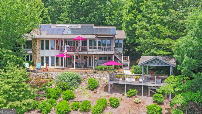 Immaculate lake front home on super, deep-water, point lot with long-range views. Fully furnished. Thoroughly updated - even the polybutylene piping has been removed and replumbing (see agreement under Documents). Solar panels offer an extremely low electric bill ($18.00 in May). Home has been professionally designed with tons of character. Large, permitted dock with new swim platform. Three-bedroom septic system. Large Craftsman-style carport, salt water hot tub, firepit, Pella and Andersen windows, two fireplaces, huge laundry/mud room on Main Level and exterior lighting surrounding the entire property. HOA fee includes trash pick-up.