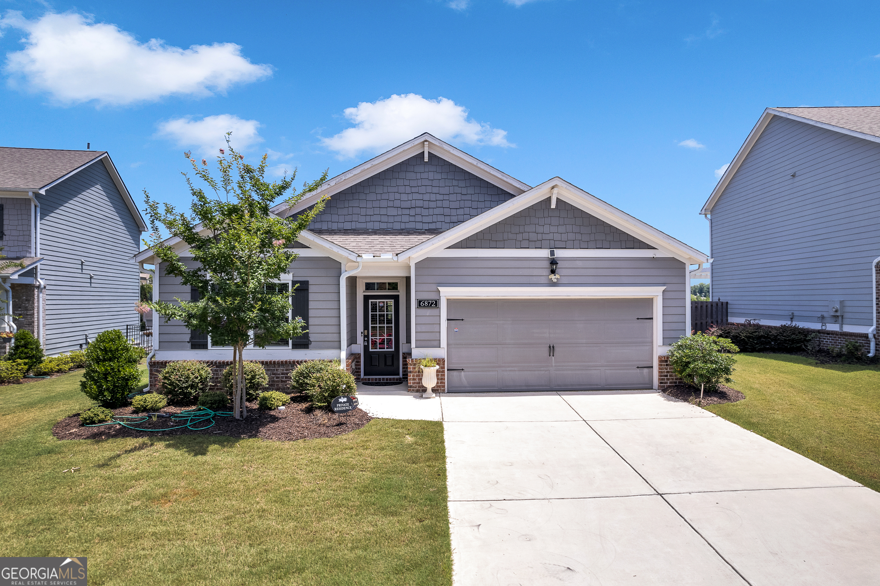 Welcome to this elegant ranch home in the sought-after Sterling on the Lake community in Flowery Branch. This home embodies comfort and elegance, offering an inviting atmosphere for all who enter. As you step through the front door, you are greeted by a wide and welcoming hallway that guides you through the heart of the home. This expansive corridor provides access to the secondary bedrooms and a bathroom, as well as the entry to the spacious garage. The hallway effortlessly leads you to the open and airy living area, creating a seamless flow throughout the house. The stunning kitchen, a centerpiece of this beautiful home, features high-end finishes with ample cabinetry, a large island, and stainless steel appliances, it's perfect for both everyday meals and entertaining guests. The master suite offers a comfortable retreat, featuring custom-installed racks in the master bedroom closet for a well-organized and stylish space. The master bathroom is equally pleasant, with elegant fixtures and a relaxing ambiance. The home has seen significant upgrades in recent years, enhancing its charm and functionality. Laminate flooring in a tasteful Gun Barrel Oak finish was installed in 2021, adding a fresh, modern touch to the bedrooms and closets. The backyard is a peaceful oasis ideal for relaxation. While the lush trees currently obscure the lake view, you'll be delighted by the scenic vista that emerges in the fall. In 2021, a cedar positive scallop fence was added, offering both privacy and aesthetic appeal without enclosing the entire yard. The spacious garage has been meticulously upgraded with sleek cabinetry that provides ample storage while still accommodating two cars comfortably. The floor has been finished with a durable epoxy coating, adding a touch of sophistication and practicality. Sterling on the Lake is a highly desirable community known for its picturesque settings, numerous amenities, and vibrant social scene. Enjoy access to lakes, walking trails, and recreational facilities that cater to a lifestyle of leisure and activity. The community is conveniently located near major highways such as I-985 and I-85, providing easy access to nearby cities and attractions. Flowery Branch offers a variety of dining, shopping, and entertainment options. Don't miss the opportunity to make this exquisite home your own. Experience the perfect blend of comfort, elegance, and inviting charm in one of Flowery Branch's most prestigious neighborhoods.