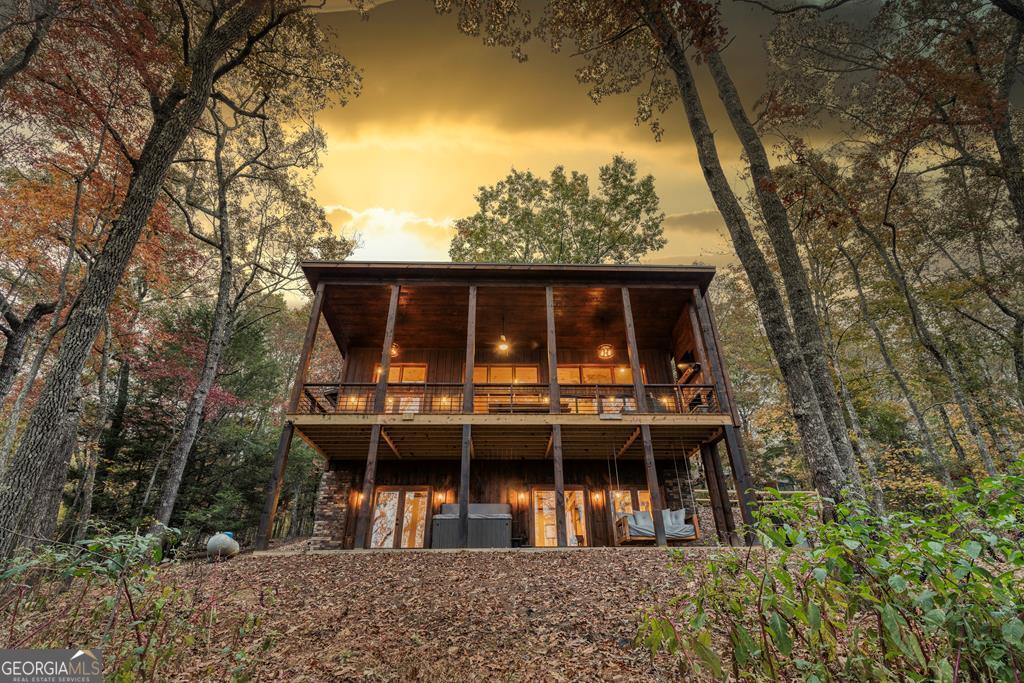 Turnkey rental investment or vacation home, averaging over $90k in gross revenue. This 3-bedroom, 3.5 bath modern chalet style home has been thoughtfully designed for both comfort and investment. The main level features an open-concept living space with vaulted ceilings, a cozy gas fireplace, and a fully equipped kitchen with a large island, dining area, and powder room. The main-level primary suite includes a king bed, attached bath with double vanity, and a luxurious tiled shower with rainfall head. Downstairs, the terrace level is made for entertaining, with a game room complete with wet bar, foosball table, arcade game, and smart TV. You'll also find two additional bedrooms (one with twin-over-twin bunks, one with a king bed), two full bathrooms, and a sleeper sofa. Outdoor living is just as impressive, with a spacious main-level deck offering ample seating, a wood-burning fireplace, TV, and picnic table. The lower patio includes a 5-person hot tub, swinging daybed, and a fire pit, ideal for cool mountain evenings. Whether you're looking for a successful short-term rental investment or a relaxing second home in the mountains, this well-maintained property is ready to go. Cabin is fully turnkey with all furnishings, decor, supplies, and marketing included. Current owners have over 100 5-star reviews and are willing to stay on as co-hosts to help the new owner continue the success of Chardonnay Chalet. Showings by appointment only, do not disturb guests. Please see the documents section for Airbnb link, rental history, and average expenses.