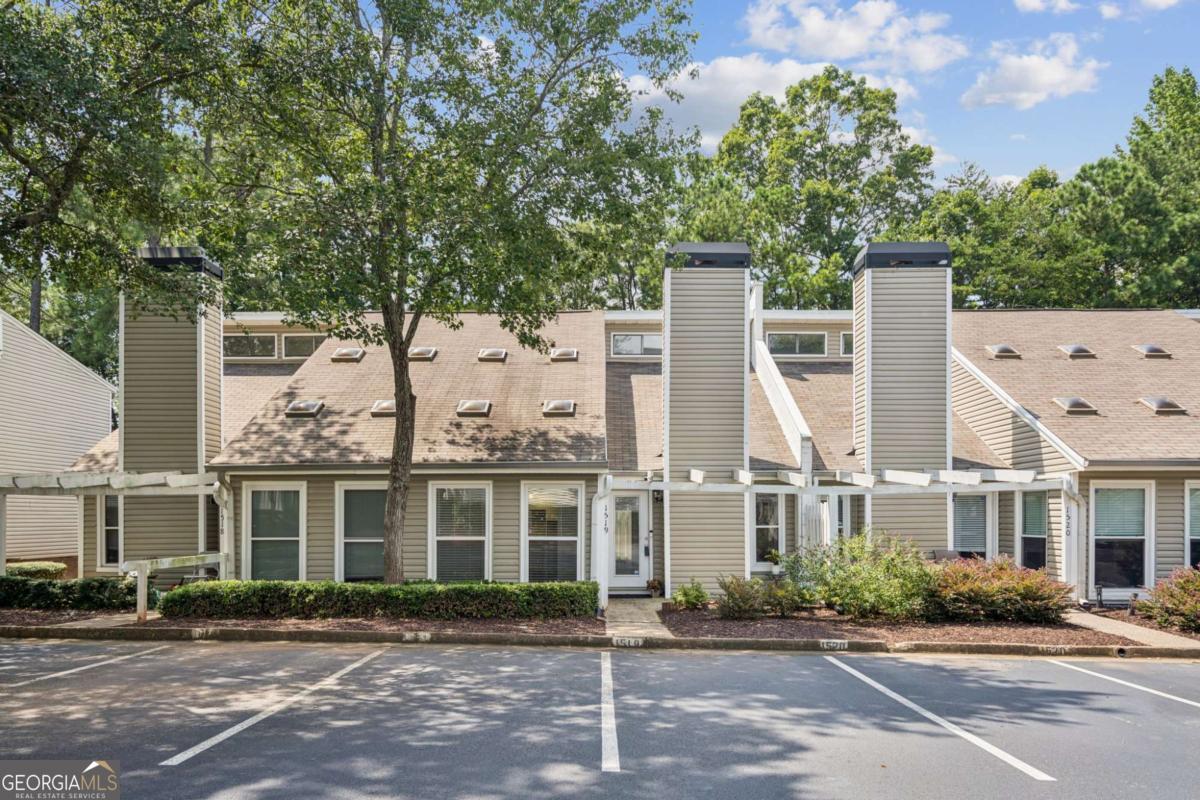 Affordable 3BR/2BA Townhome with OWNERS SUITE ON THE MAIN-LEVEL nestled in a quiet subdivision in the heart of Alpharetta. Well maintained and priced to sell, this home offers an excellent opportunity for buyers to add their personal touch and make updates to suit their style, all while building equity in one of North Metro Atlanta's hottest zip codes. NEW CARPET THROUGHOUT this great floorplan. The main-level living areas include a spacious open great room with vaulted ceilings and a cozy fireplace, an open layout functional kitchen, a flexible dining area, and a large sun-filled multi-functional space that would make the perfect home-office, relaxing sunroom/reading nook, or playroom. The spacious main-level owner's suite offers an ample walk-in closet, a large private bath, and walkout access to the private, rear patio. Two roomy upstairs bedrooms share a full bath. This unit is nestled near the back of this quiet subdivision and backs-up to tree-lined privacy. Additional features include a front porch sitting area, a stepless entry, two assigned parking spaces conveniently located right outside your front door, and a prime location just 1.5 miles to Avalon (with walkable sidewalks along the whole route), 1.5 miles to GA-400 Exit 11 (Windward Pkwy), 2.5 miles to GA-400 Exit 10 (Old Milton Pkwy), and just a quick ride or walk to a multitude of shopping, restaurant, and entertainment venues. Zoned for top rated schools: Manning Oaks Elementary, Hopewell Middle, and Alpharetta High. The subdivision amenities include a pool and sport-court, peaceful greenspace buffers, side-walks throughout, and low-maintenance living. This property offers a fantastic foundation to create your dream home or add to your rental portfolio in this high demand area with no rental cap (6 month minimum rental term required).