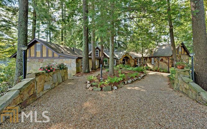 Witham Point's "Withmere".First time on the market. Lake Rabun's premier historical property on 2.98 ac of Fee Simple Property.More than 1200 feet of private shoreline.The home was originally built in 1921 as a summer Scottish inspired hunting lodge.The home boasts a grand lodge room with timber framed beam construction and a massive fireplace.The south wing is comprised of 3 BR and 2 ba.The north wing houses a large dining room, screen porch room,1 BR and 1 ba, & a prep kitchen. Stone terraces & patios surround the exterior. The lower terrace level is the site of the old kitchen, work areas & additional service rooms.The majestic grounds lead down multiple trails to the waterside and a 2 stall covered boathouse.Also included are a guest house & 2 car garage