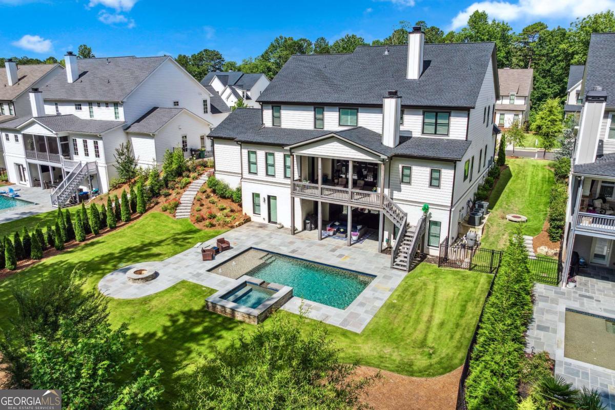 Gorgeous Estate in South East Cherokee County. A True Masterpiece of Design and Comfort. This exceptional multi-generational home is the epitome of elegance, nestled on a private, scenic lot. Boasting 6 generously sized bedrooms and 6 full bathrooms plus two half baths. This home offers unmatched luxury, thoughtful design, and exquisite finishes. Perfect for both family living and entertainment. From the moment you step inside, you'll be captivated by the rich hardwood floors that span the entire home, creating a warm, inviting atmosphere that flows seamlessly from room to room. The heart of the home is undoubtedly the gourmet kitchen featuring quartz countertops, high-end appliances, custom cabinetry and an oversized island. This home offers the rare and luxurious feature of two primary suites, each a sanctuary of privacy and relaxation. Both suites are designed with spa-inspired bathrooms with rainfall showers, dual vanities and his and her water closets. Every upper-level bedroom is accompanied by its own en-suite bathroom, offering privacy for family members or guests. The bathrooms feature high-end finishes, such as designer tile work, modern fixtures, and beautiful countertops. The terrace level offers an additional bedroom with an ensuite bath, and a sitting area that can serve as a private retreat for guests or extended family. The media room provides a perfect setting for movie nights. The open layout offers a beautiful wet bar with an ample amount of entertainment space. Step outside and immerse yourself in an extraordinary outdoor living space. The saltwater pool is complemented by a hot tub, both surrounded by blue stone decking, and a fire pit for relaxing under the stars. The circular driveway creates a welcoming entrance that is convenient with plenty of room for guests to arrive in style. This home is truly a rare gem. Every detail has been carefully considered to provide a lifestyle of ultimate comfort and elegance. Close proximity to Creekview High School. There is the option to join Woodmont Golf and Country Club to access sports facilities and pool.