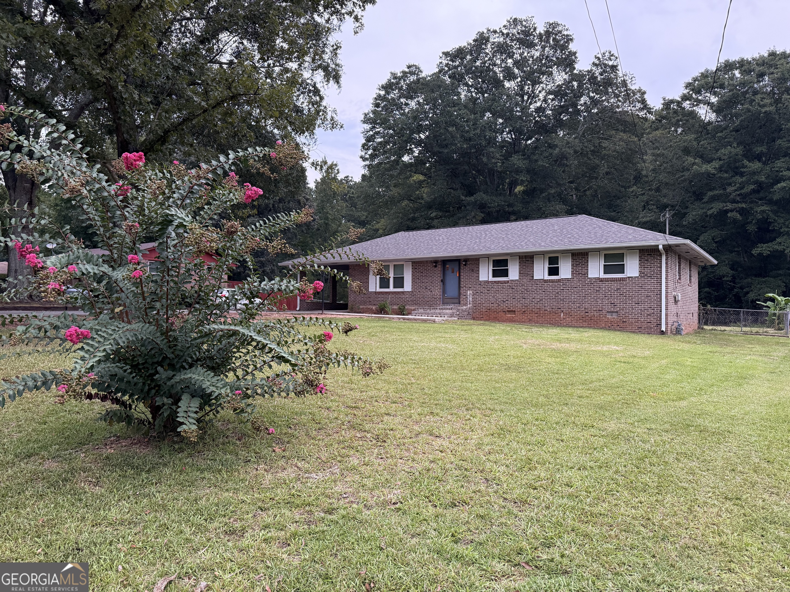 This lovely home in Griffin boasts three spacious bedrooms and two bathrooms. The living area is open and inviting, with a convenient laundry room off the kitchen. Two bedrooms feature a unique Jack and Jill bath design. The backyard is fenced in and features a large workshop with a concrete floor and electric power. An attached carport on the back of the house includes a spacious storage room. The back deck overlooks a beautiful yard perfect for gardening and outdoor activities. The neighborhood is known for its peaceful atmosphere, with streetlights providing illumination. Don't miss out on this opportunity to make this house your forever home. Contact Sky or your agent to schedule a showing today.