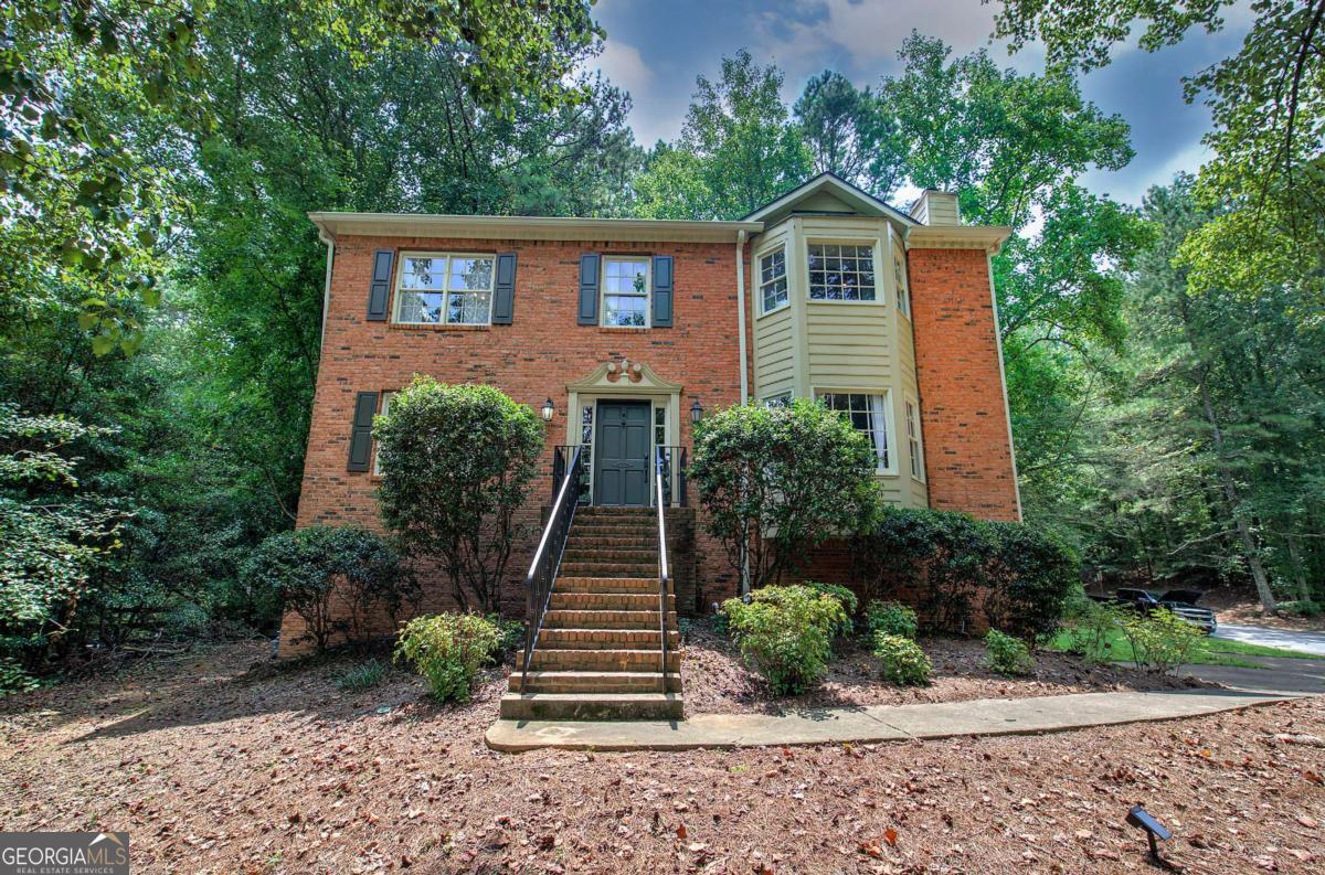 Full of charm and character, this home is ready to welcome you! Thoughtful details are found throughout, with architectural trim on many walls adding style and interest. The spacious living room features gleaming wood floors, built-in bookshelves, and a gorgeous brick fireplace, creating a cozy gathering space. The galley kitchen sits perfectly between a sunny breakfast area and a formal dining room, offering great flow for entertaining. With a ceramic sink, new dishwasher, built-in pantry, and rich stained cabinetry, the kitchen blends warmth and function. The main level also includes a convenient half bath and a versatile room-ideal for an office, playroom, or cozy reading den. Upstairs, you'll find two generous bedrooms and a master suite full of character, complete with its own fireplace and charming window seat. The ensuite bath feels like a retreat, with dual sinks, a separate shower, and a grand Jacuzzi bathtub. The oversized garage offers ample storage, project space, and even its own toilet and sink. Step outside to enjoy a large deck with built-in bar seating, plus a gazebo wired for electricity-perfect for gatherings rain or shine. The fenced backyard provides room to play, a fire pit area, and low-maintenance landscaping with recently pruned trees. Additional highlights include newer steel exterior doors for security and updated fixtures throughout. Conveniently located near I-75 and I-575, this home puts you just minutes from vibrant downtown Woodstock, Kennesaw, shopping, dining, and more!