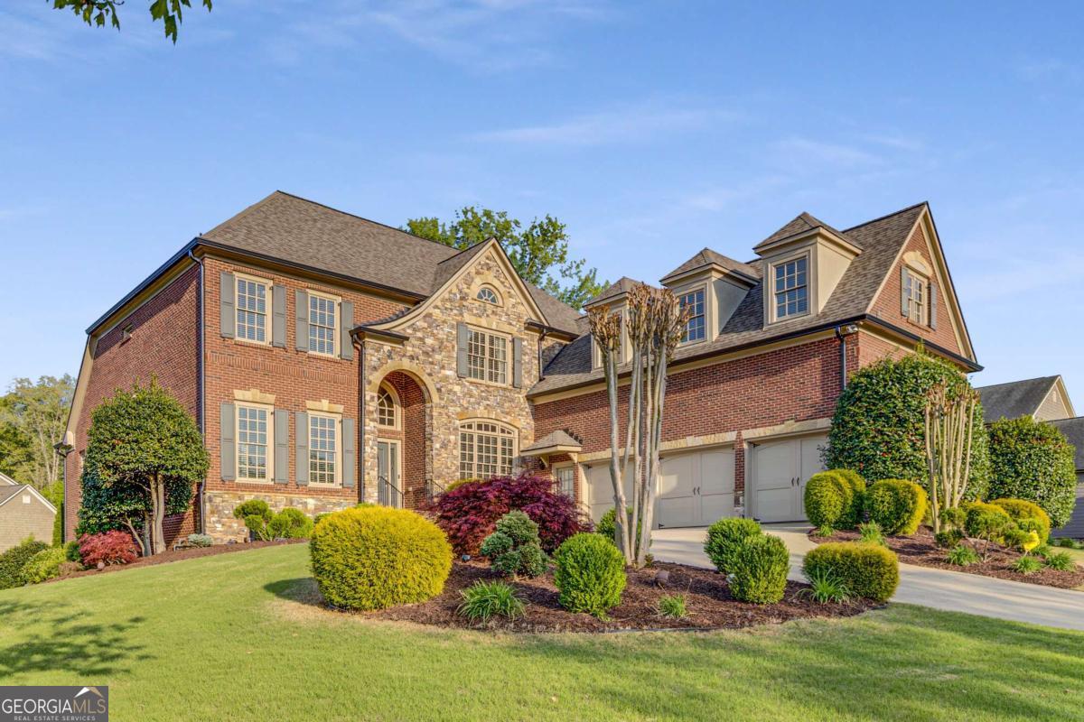 Welcome Home to this stunning former Model Home, a masterpiece of design and detail showcasing premium finishes and thoughtful upgrades at every turn. Situated in the sought-after Hillgrove High School district, this residence offers 7 spacious bedrooms and 5.5 bathrooms, including a luxurious Primary Suite on the Main Level with direct access to the back deck. Step into elegance through a dramatic two-story foyer that sets the tone for the rest of the home. To the right, a formal dining room comfortably seats 12-perfect for hosting special gatherings. Just beyond, the tray-ceiling family room connects seamlessly to a beautifully appointed kitchen featuring granite countertops, a coffee bar, a walk-in pantry, and an open-concept layout ideal for entertaining. The cozy sitting room boasts coffered ceilings, a fireplace, built-in shelving, and stunning floor-to-ceiling windows that fill the space with natural light. Tucked away on the left wing is the serene primary suite with a spa-like bathroom that includes double vanities and a Jacuzzi tub. Enjoy outdoor living with a covered deck and patio, perfect for entertaining or quiet evenings. The main level also features a laundry room and a three-car garage with a 240V electric vehicle charger. Upstairs, you'll find generously sized secondary bedrooms and a spacious media/flex room with brand new carpet-offering endless possibilities for a playroom, theater, or home office. Downstairs, the fully finished basement spans over 2,200 sqft and includes a home gym, game room with bar and pool table, separate living area, two additional bedrooms, bonus room, an accessible full bath, full kitchen, and a secondary laundry closet-making it ideal for multigenerational living or guest accommodations. A large unfinished room provides even more storage or project space. Set on a beautifully landscaped corner lot directly across from the neighborhood pool and playground, this home is a rare combination of luxury, space, and unbeatable location in the heart of West Cobb.
