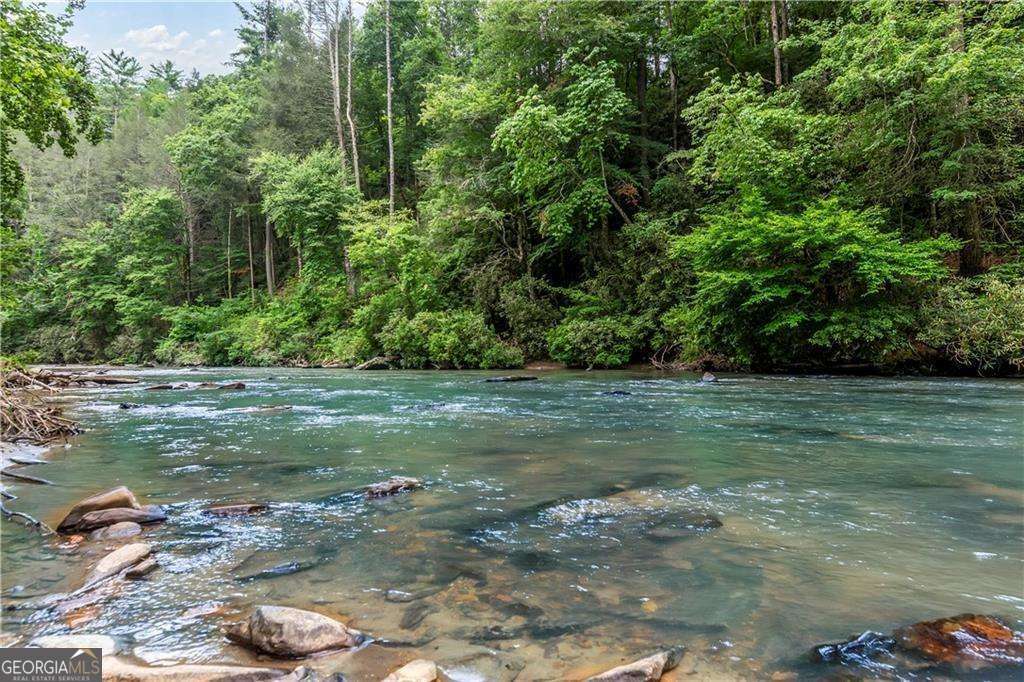 Nestled in a small mountain community on the infamous Mountaintown Creek is this lovely 13.23 +/- acre piece of property awaiting your personal touch to make it a dream vacation home, full-time residence, or successful rental. This property checks every box a prospective buyer could have when considering property in North GA. Want over 1,000 feet of creek frontage on one of the most popular trout streams in North GA? Check! Want a great lot that could offer stunning mountain views with pruning and landscaping? Check! Looking for the right land that can be further divided into several lots to bring along your family and friends and have more than one house? Check! The property has already been soil tested and approved for septic. Tens of thousands of dollars in clearing already done with pre-cut driveways in place. Property lines are clearly marked, and a new survey was recorded just a year ago! Need to make a trip to town? Take a short, approximately 8 mile drive to downtown Ellijay and enjoy restaurants, boutiques, festivals, and more! STRs are allowed. Inquire for more details!