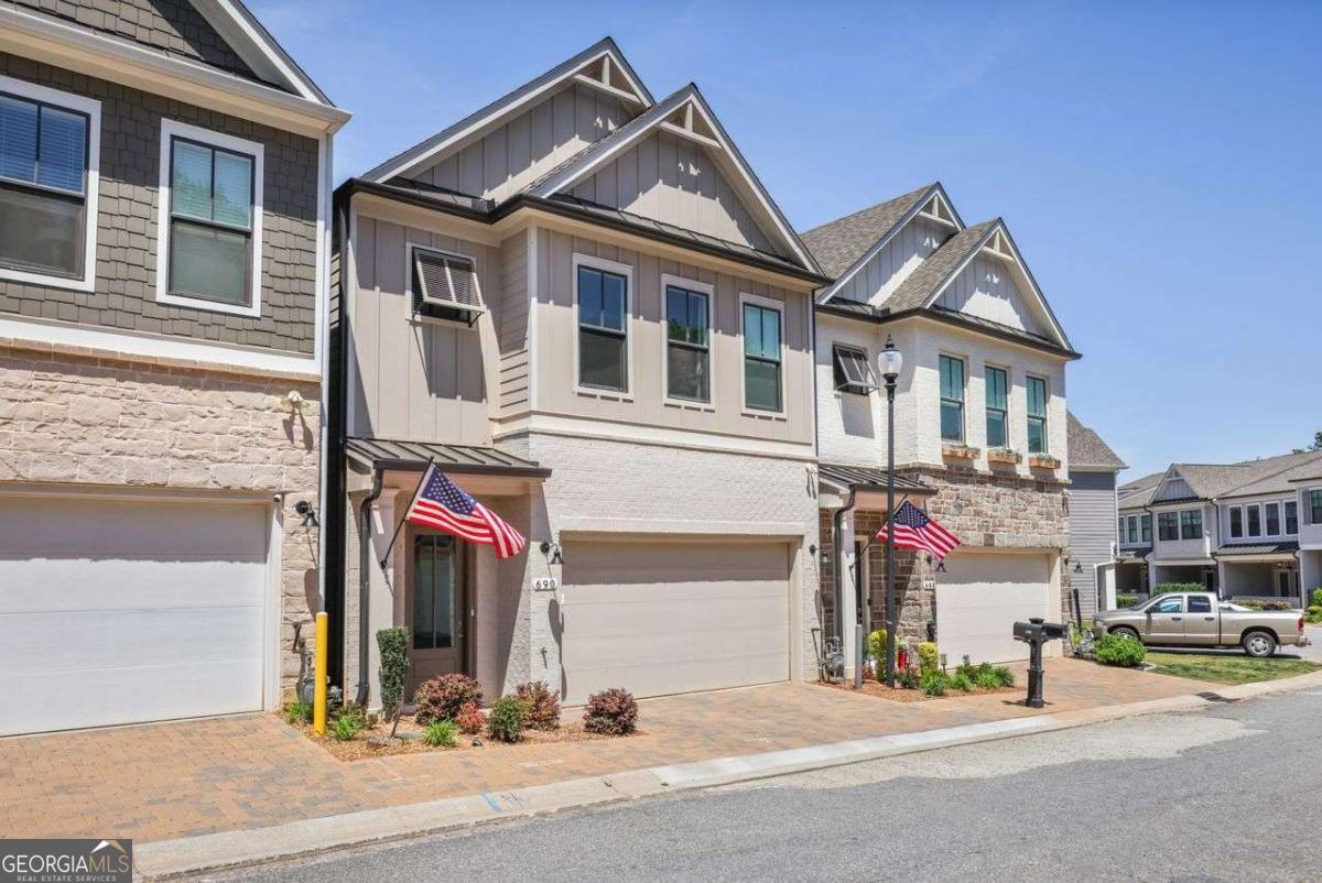 Immaculately maintained and beautifully upgraded courtyard-style home with a spacious open floor plan and owner's suite on the main level. Soaring 11ft ceilings on the main and 10ft ceilings upstairs. Gourmet kitchen features 42ft solid maple Wellborn cabinets, quartz countertops, stainless steel appliances, and a large skylight that fills the space with natural light. COREtec 9ft luxury vinyl plank flooring in main living areas (waterproof & pet-proof), ceramic tile in all baths and laundry. Owner's suite includes direct courtyard access, oversized shower with tile to ceiling, double vanities, and custom Spacemakers closet with 2nd laundry hookup. Upstairs offers two large bedrooms (one with private bath), a loft, huge bonus room, and upgraded laundry with full sink and cabinetry. Upgraded lighting throughout. Paver driveway, courtyard, and 2-car garage. Smart fridge with matching panels and stackable washer/dryer in main-level laundry stay. Located conveniently near guest overflow parking and one of the dog parks. Gated community with clubhouse, pool, gym, outdoor fire pit, pool table, game area, and three turfed dog parks. Minutes to downtown Woodstock with shops, dining, and events. This home stands out with thoughtful design, luxury finishes, and unmatched convenience!