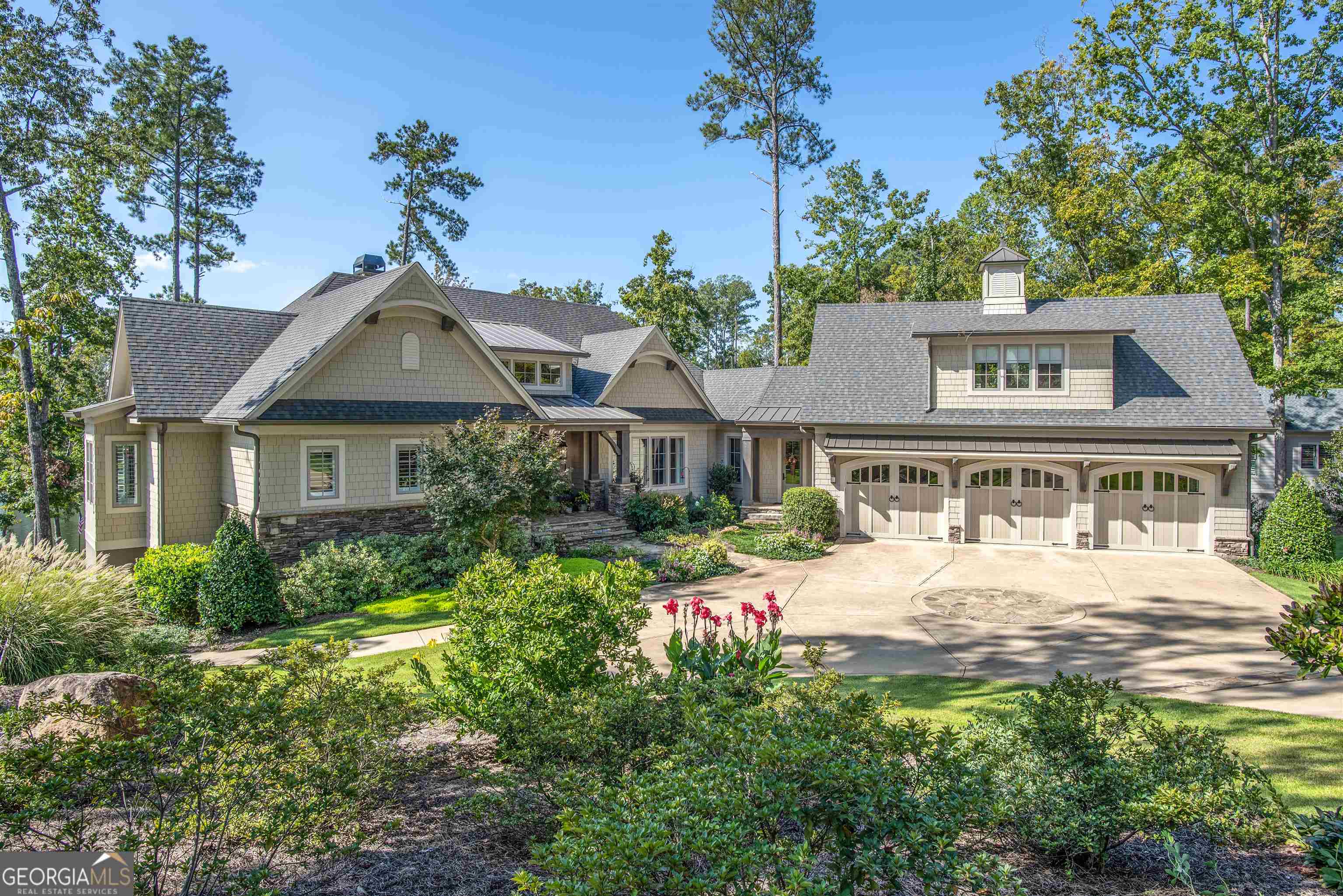 Stunning like-new custom lakefront home located in prestigious Horseshoe Bend of Reynolds Lake Oconee. This home, built by DreamBuilt and designed by Black Sheep Interiors, epitomizes quality and luxury living. As you step inside, you'll immediately appreciate the craftsmanship and attention to detail. The main level boasts an open floor plan with breathtaking lake views, highlighted by a custom barrel wood ceiling in the foyer, a vaulted great room with cypress beams, and a dining room. An arched doorway leads to a private powder room, and a wood-burning fireplace adds warmth and charm. The large butler's pantry and a breakfast room with a custom bar featuring iron and glass doors are perfect for entertaining. The expansive screened porch with pecky cypress ceiling and fireplace overlooks the lake. You'll also find a unique 300+ year-old antique French door leading to the primary suite. The primary bathroom offers a luxurious experience with its marble doorless shower and double vanity. A convenient laundry room is also on the main level. Above the garage, you'll discover spacious rooms with full bath that can be used as an office or additional living space/bedroom. The terrace level is designed for relaxation and entertainment, featuring a generous family room with custom built-ins w/English vicary doors, a wet bar with real brick veneer, and hardwood floors throughout. There are 3 guest suites, each with its own bathroom. Plus, there's an impressive 1,000+ sq ft workshop/bonus room for your hobbies and projects. Walk out onto the beautifully landscaped backyard which is a true oasis, complete with a fabulous outdoor stone patio with swing beds perfect for watching your favorite games, spa pool, stunning lake views, your own private boat dock, and a fire pit. Home is elevator-ready. This home offers a location that's unparalleled, with proximity to the Ritz-Carlton and all the amenities Reynolds Lake Oconee has to offer. It's an idyllic lake house for those seeking the ultimate in lakeside living. Conveniently located within boating minutes to the Ritz, Richland Pointe and Great Waters, and minutes by car to the new Richland Pointe amenity center. Membership available.