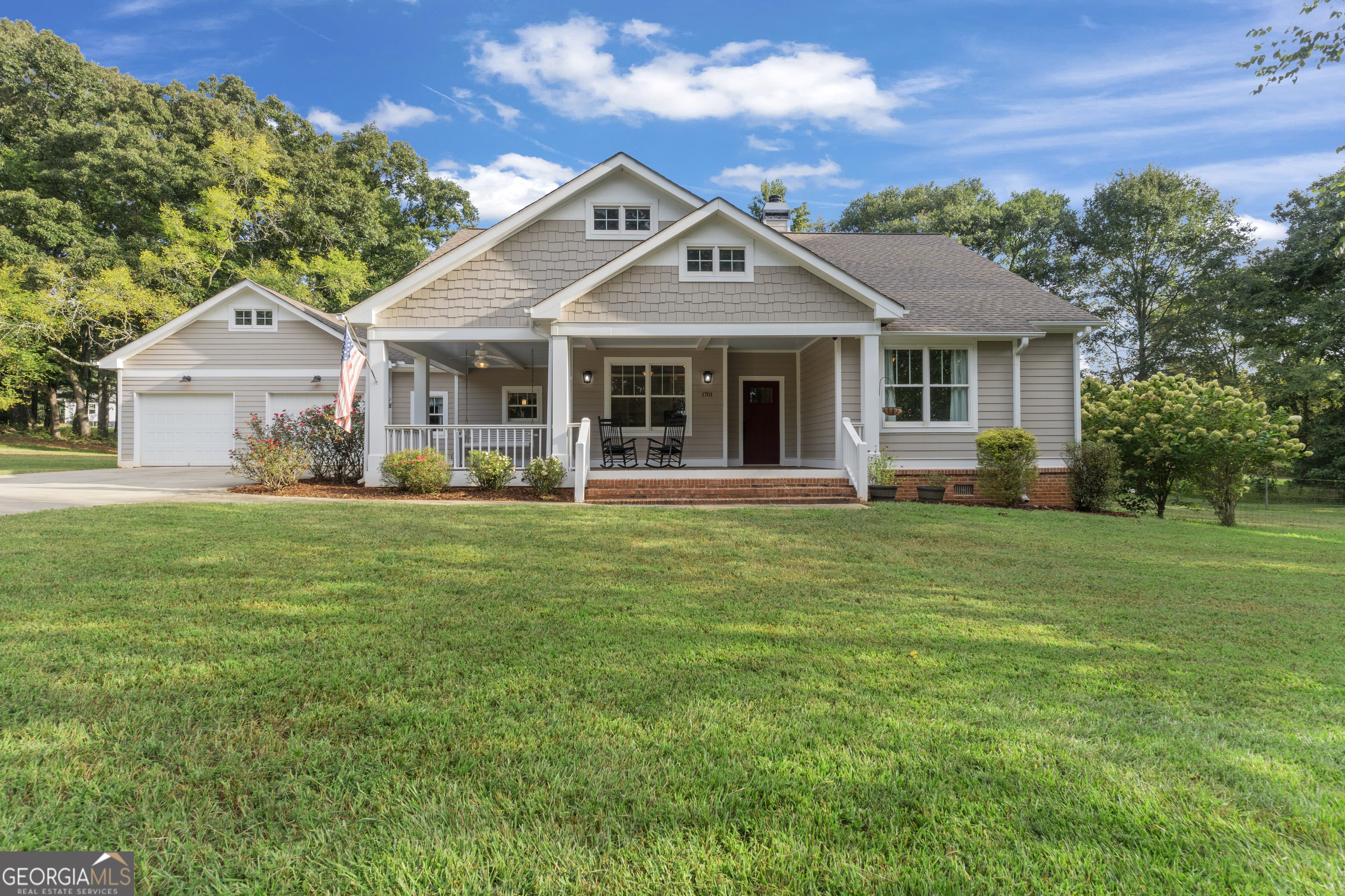 Welcome to your country slice of paradise!!! This charming Craftsman-style ranch, nestled on 5 serene acres, offers the perfect blend of elegance, comfort, and functionality. From the moment you arrive, you'll feel right at home in this peaceful retreat just minutes from Downtown Madison, top-rated schools, and I-20. Step inside to a spacious living room featuring soaring 11-foot ceilings and a cozy wood-burning fireplace. The stunning kitchen is a true showstopper, showcasing custom cabinetry, gleaming quartz countertops, stainless steel appliances, and a generous island ideal for gathering with friends and family. Adjacent to the kitchen, the dining room provides the perfect setting for hosting. The expansive owner's suite is a true sanctuary with a luxurious en-suite bath, dual closets, and private access to the back porch-perfect for enjoying your morning coffee while taking in the beauty of nature. Two additional bedrooms and a full bathroom are thoughtfully located at the front of the home, alongside a versatile office or playroom complete with built-ins. A spacious laundry room/walk-in pantry and convenient half bath are located on the opposite side of the home, ensuring functionality and ease. Step outside and take in the breathtaking views of mature trees and open space. A massive 34x40 barn/workshop-with electricity, plumbing stubbed for a future bath, and an upper-level loft-offers endless possibilities for hobbies and storage. This home truly has it all-schedule your private tour today and fall in love!