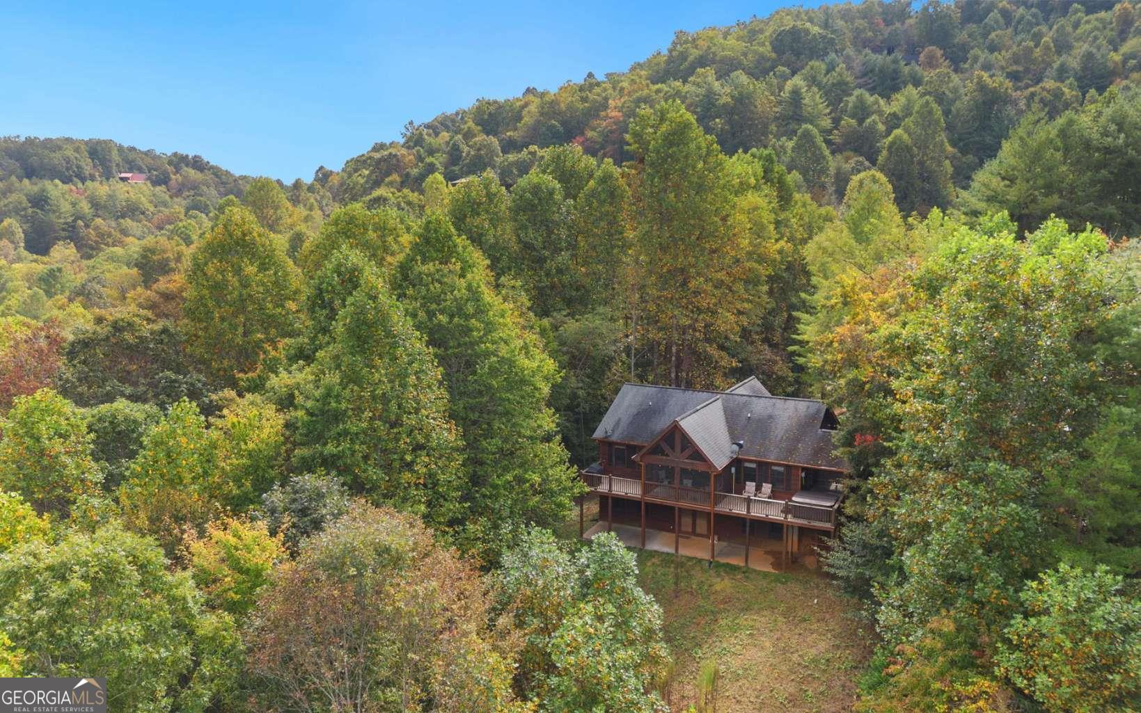 Welcome to stunning long-range mountain views in this captivating 3-bedroom, 3-bath cabin, designed for those ready to make their mark. This home exudes charm and sophistication, featuring exquisite wood finishes and stylish tiled bathrooms that create an elegant ambiance. With recent upgrades including new appliances and a water heater, this cabin seamlessly blends modern conveniences with timeless appeal. Each of the three ensuites-including two luxurious master suites-ensures comfort and privacy for you and your guests, while the additional half bath enhances functionality. Pamper yourself in the ensuite's double vanity and unwind in the relaxing jacuzzi tub, all set against beautifully tiled flooring. Additional features include convenient all-paved access, a spacious kitchen ideal for entertaining, and a newly added screened porch-a perfect retreat to enjoy nature's tranquility. The finished basement adds versatility with a game room and an extra master suite, offering plenty of space for relaxation and fun. Fully furnished and ready for rental opportunities, this cabin is your chance to create the ultimate mountain sanctuary, just minutes from Downtown Blue Ridge-a true paradise for outdoor enthusiasts.