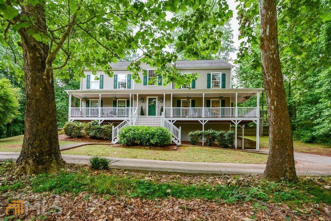 This is the home you have been waiting for in sought after Cobb County and Wheeler High School location. Southern living at it's finest and you will fall in love with the front porch on this beautiful home for hours of relaxation and enjoyment. Fantastic welcoming foyer leads to oversized family room that features custom built cabinets on each side and gas starter fireplace. Large formal dining room. Open bright sunny eat in kitchen with lots of counter space and cabinets. French doors lead out to your deck overlooking the back yard. Master bathroom and luxurious master bathroom are just one of the " WOW" factors on this home. All secondary bedrooms are oversized with excellent closet space. Two driveways for extra parking. Driveway is recorded deed easement. Don't miss this incredible one of a kind home in this amazing location. No home owners association so bring your RV or boat !!! Call today.