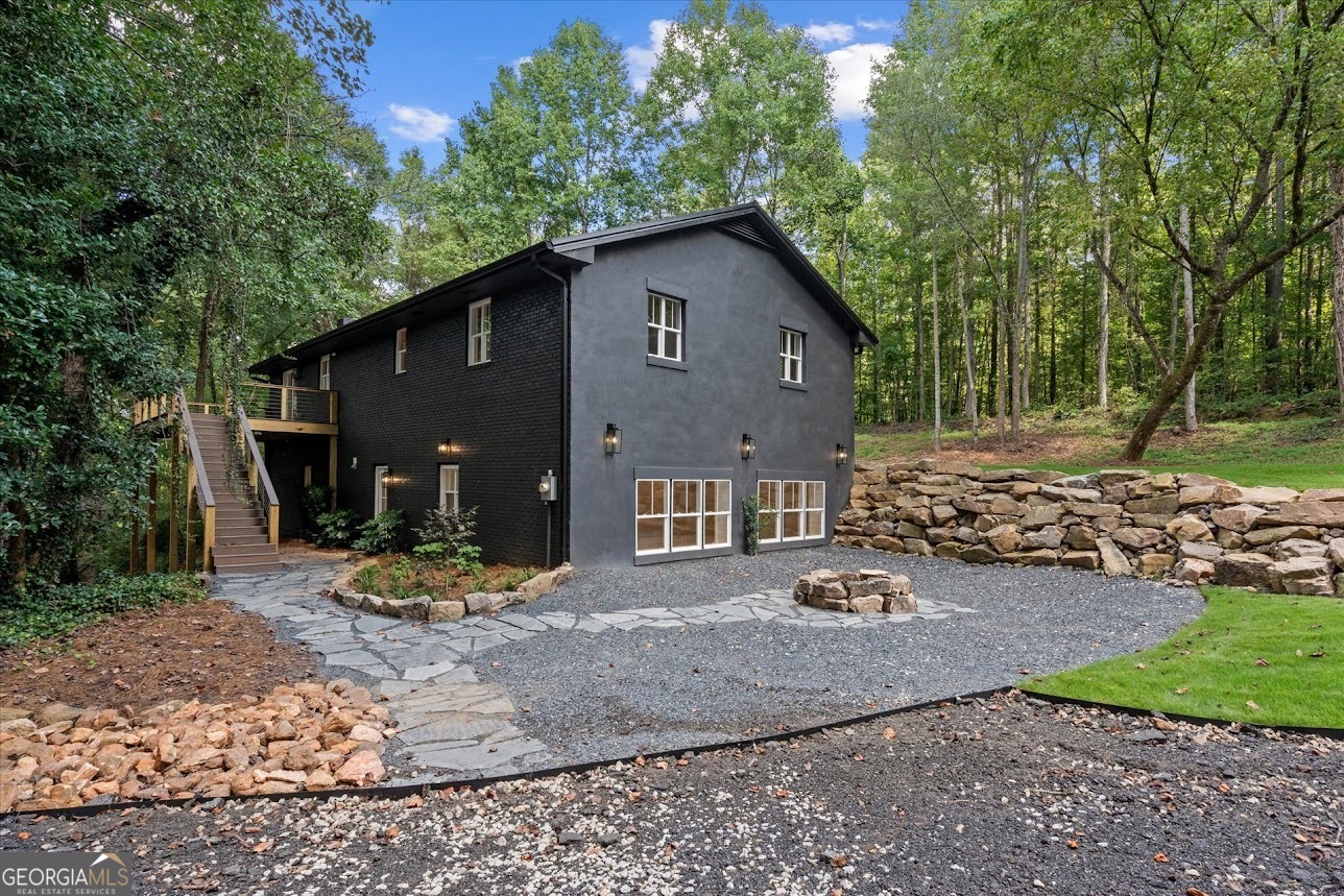 Welcome to your dream home that was completely renovated down to the studs and designed with modern living in mind. Nestled on 4 private acres with a running creek, this property offers both luxury and tranquility. Inside, you'll find 4 spacious bedrooms and 3 full bathrooms, each featuring custom touches that set this home apart. The custom kitchen is perfect for entertaining, and flows seamlessly into the open living area, anchored by a brick fireplace for warmth and charm. The fully finished basement offers a living room with a fireplace, a private bedroom, and a full bathroom, an ideal setup for guests, in-laws, or even an income-producing suite. Step outside to enjoy beautifully landscaped grounds, a cozy fire-pit, and stone steps leading down to the creek. All you need for the perfect backdrop for peaceful mornings or evenings under the stars. This rare property blends modern updates with natural beauty and is move-in ready for its next owner to enjoy for years to come. Don't miss the chance to own this one-of-a-kind creek-side retreat! Located within the Central school districts.